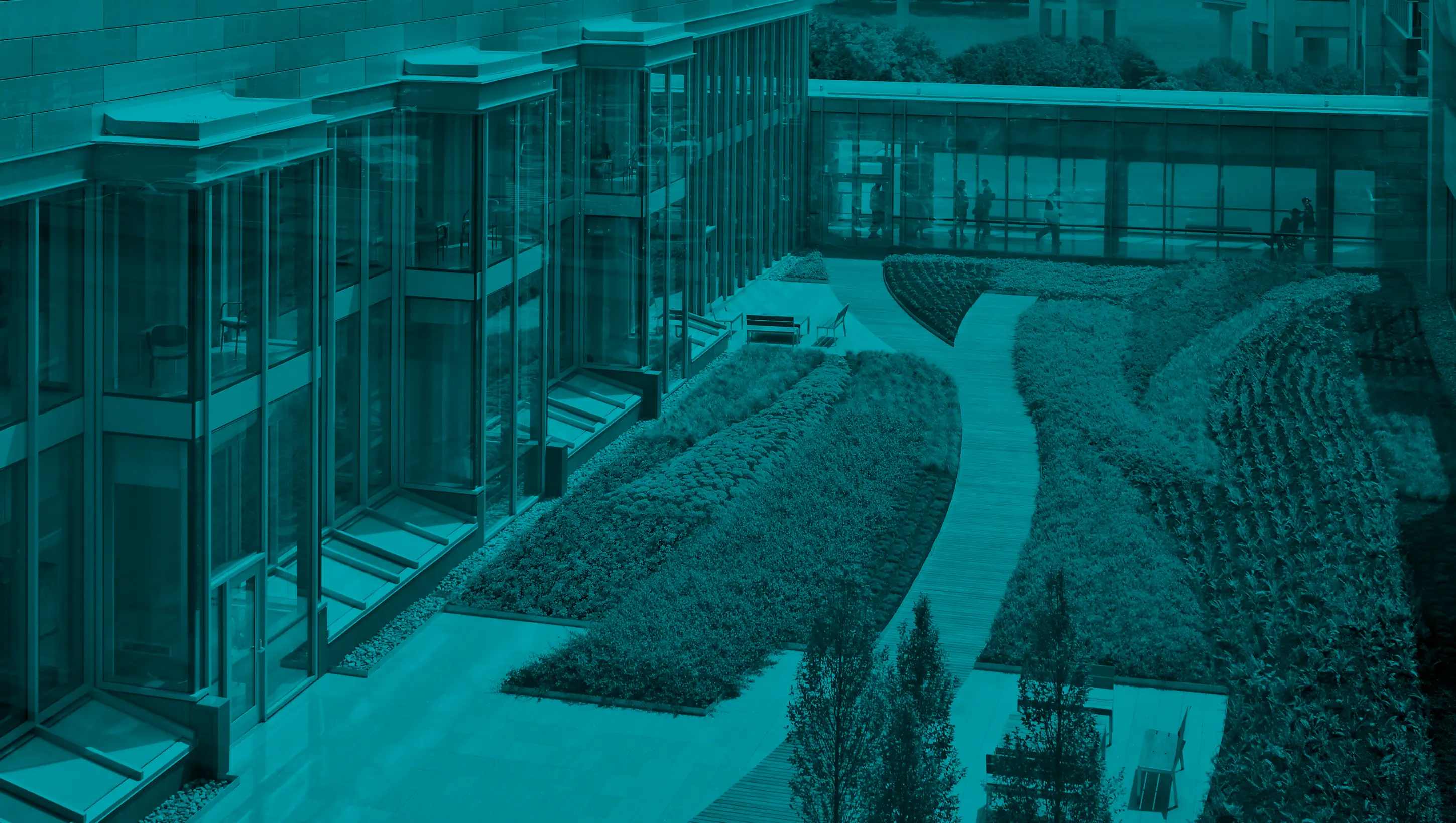 Modern building with landscaped courtyard and walkway.
