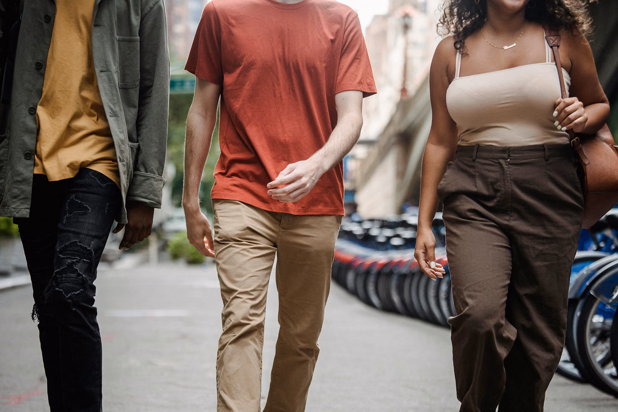 Three individuals walking down street