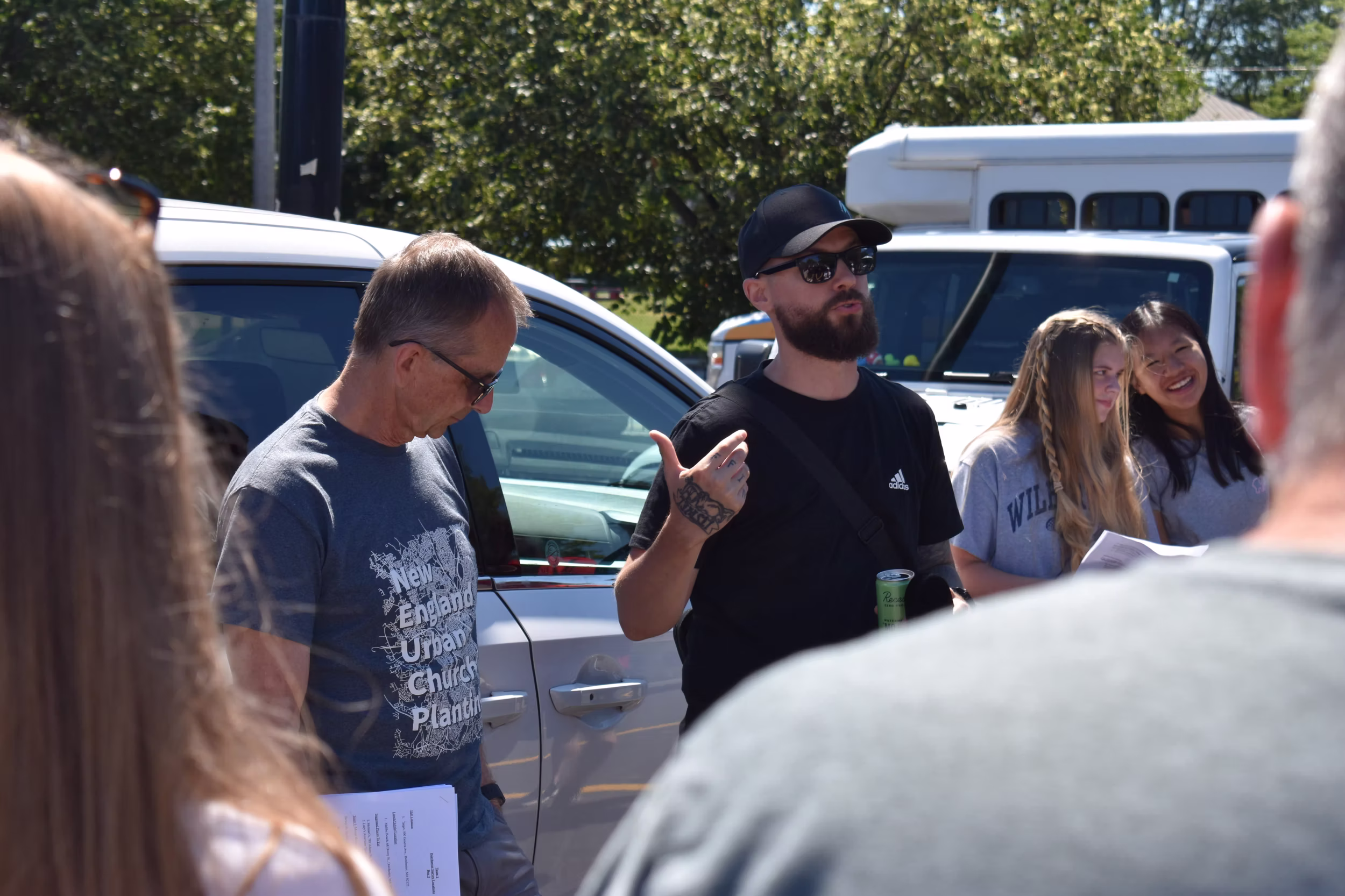 A man in black speaks to a crowd.