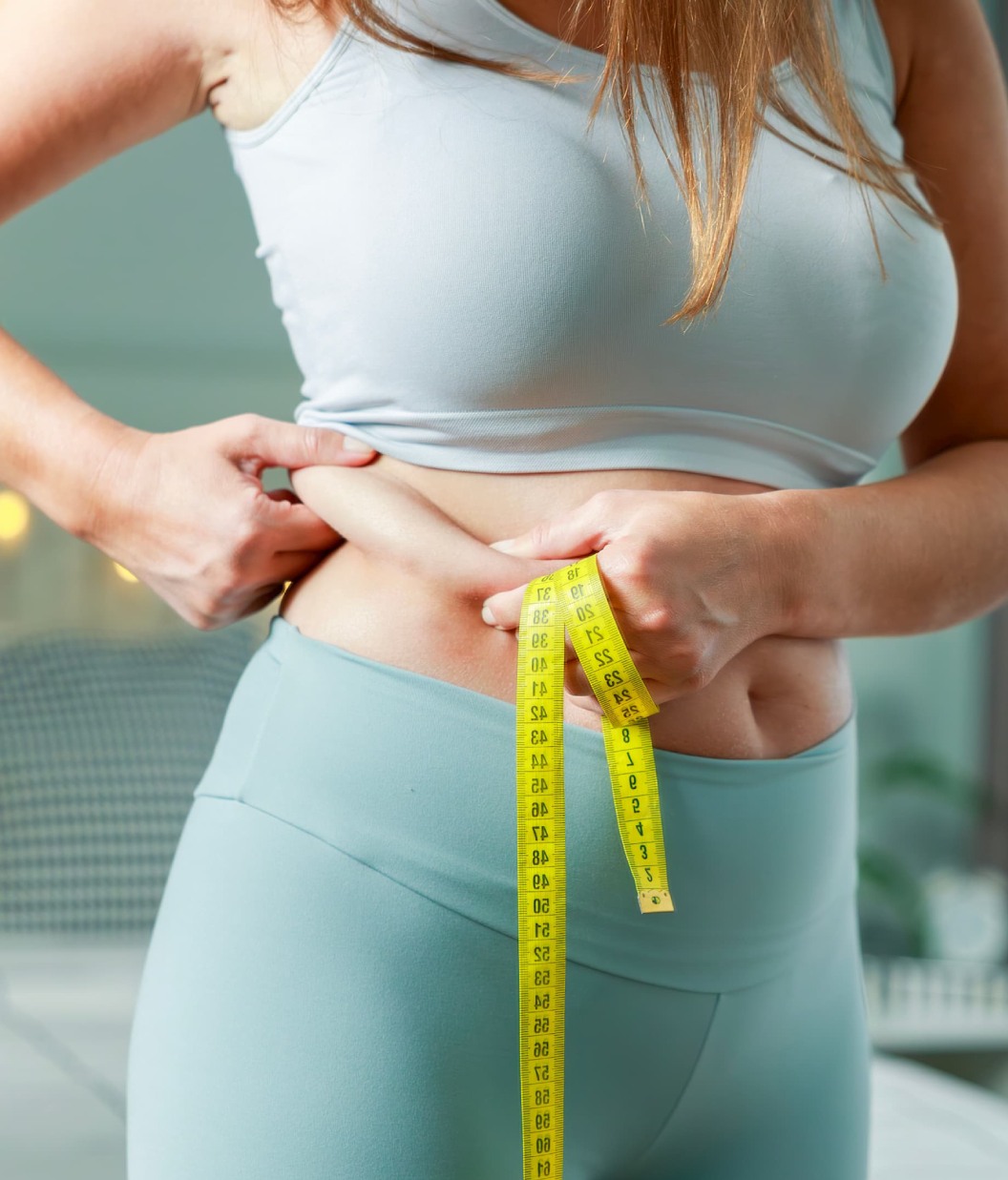 A woman measuring her waist
