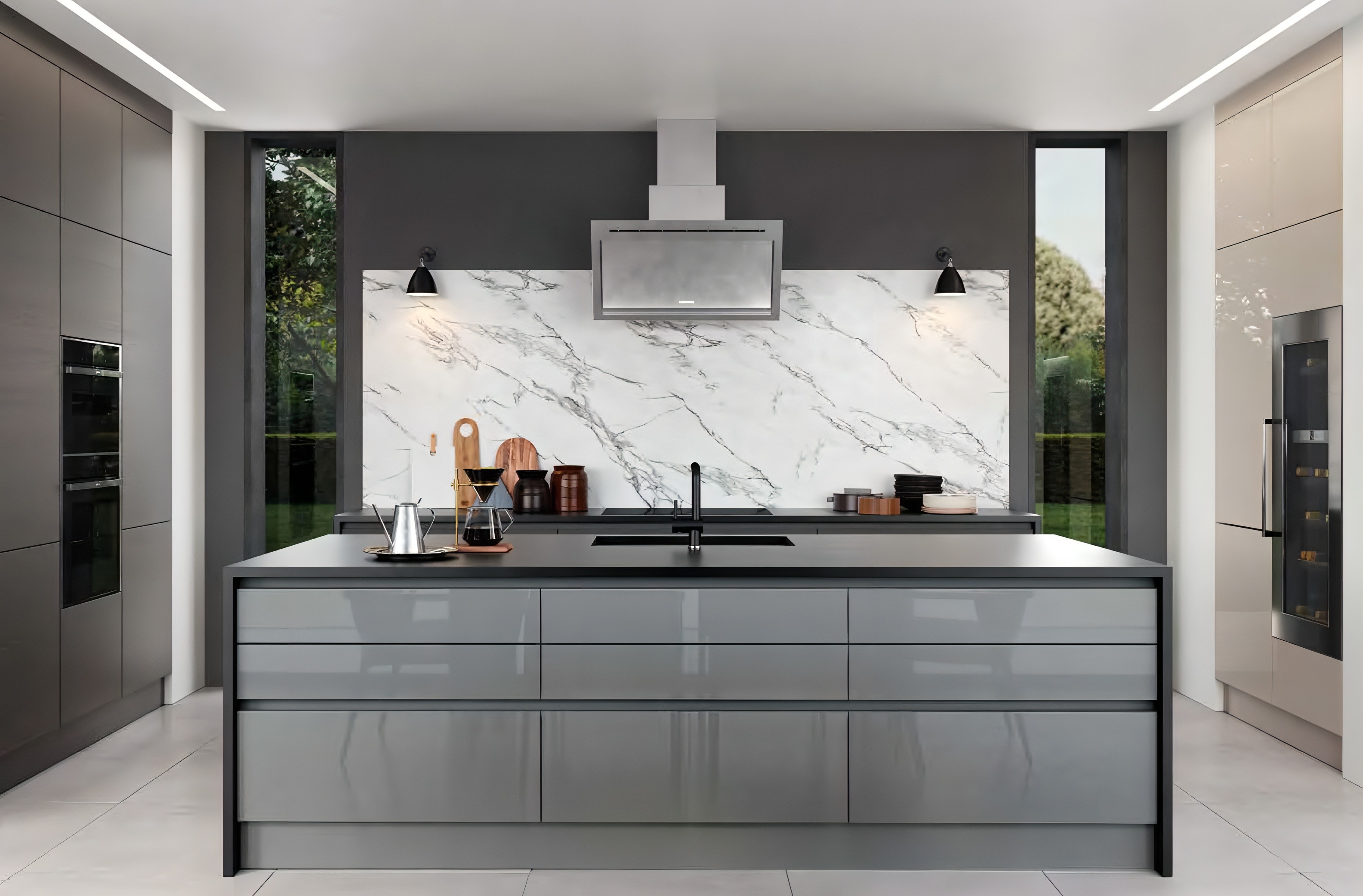 Modern kitchen with gray island, marble backsplash, black sink faucet, wall-mounted range hood, and tall windows on each side.