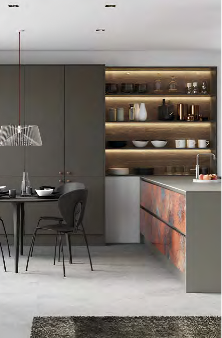Modern kitchen with dark cabinetry, illuminated open shelves holding kitchenware, a dining table with black chairs, and an island featuring a colorful textured front panel.