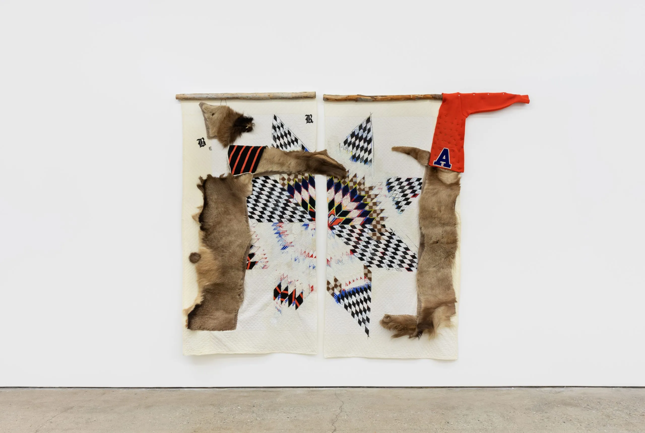 Large wall hanging, in two companion pieces, with an off-white background, with a quilted star, animal pelts and a red sweater.  
