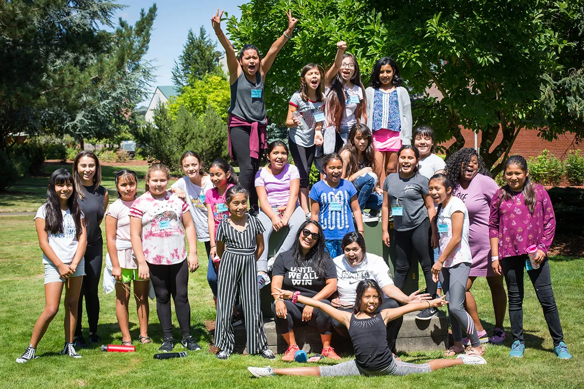 A large group of young girls posing in a pyramid shape, smiling