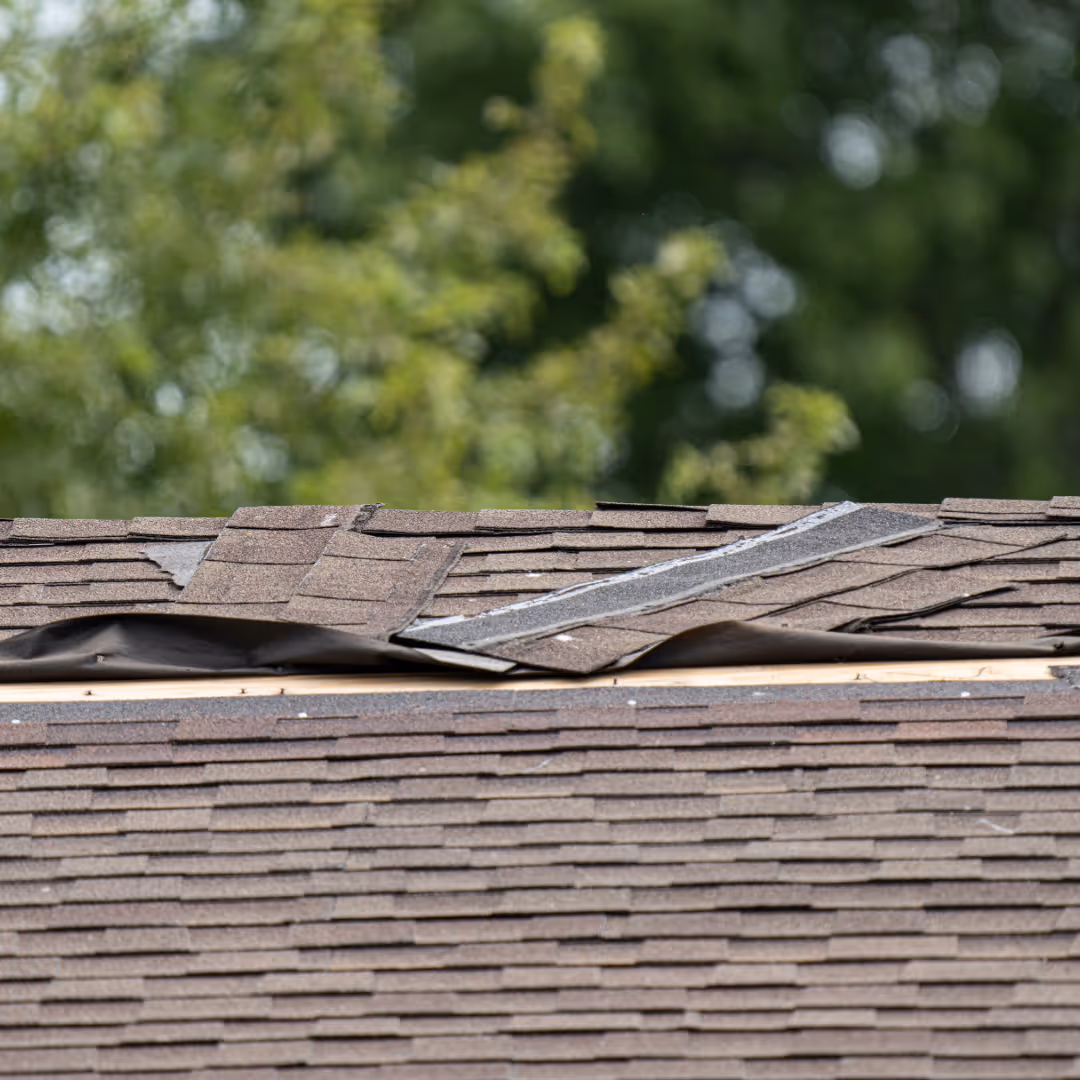 An aerial Drone photo of a client of Golden Eagle Roofing. A completed roof with an elegant sunset.
