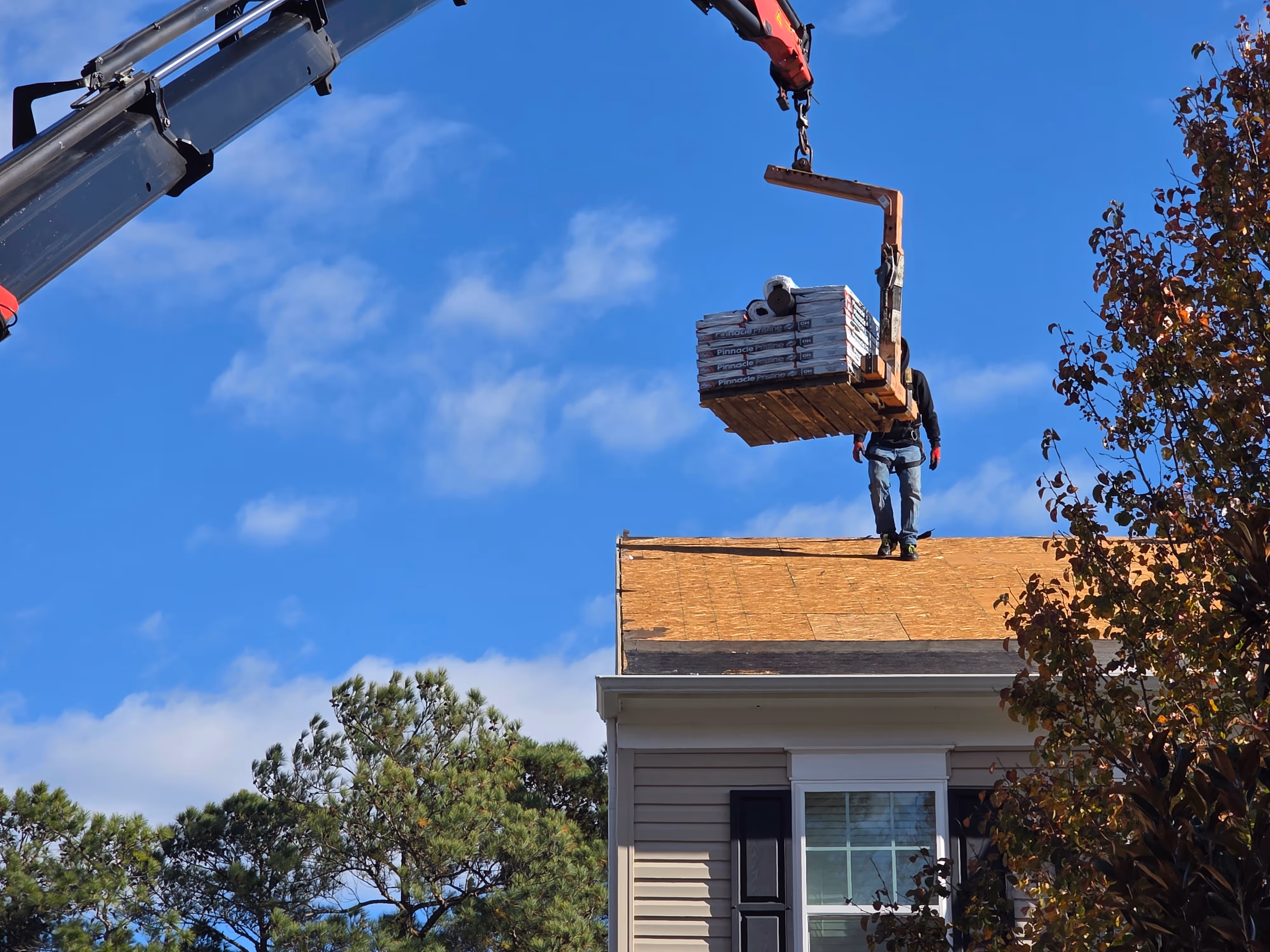 An aerial Drone photo of a client of Golden Eagle Roofing. A completed roof with an elegant sunset.