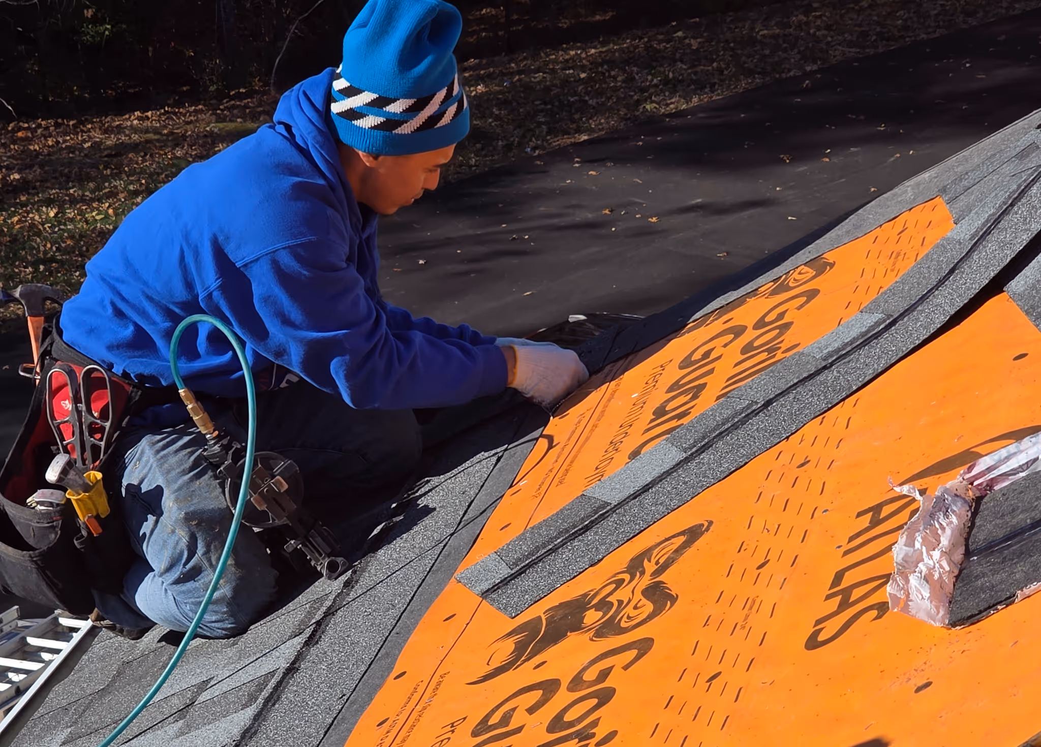 A photo of a crane loading a townhome with Atlas Pinnacle Pristine roof shingles for a insurance-paid roof replacement in North Beach, Maryland by Golden Eagle Roofing, LLC