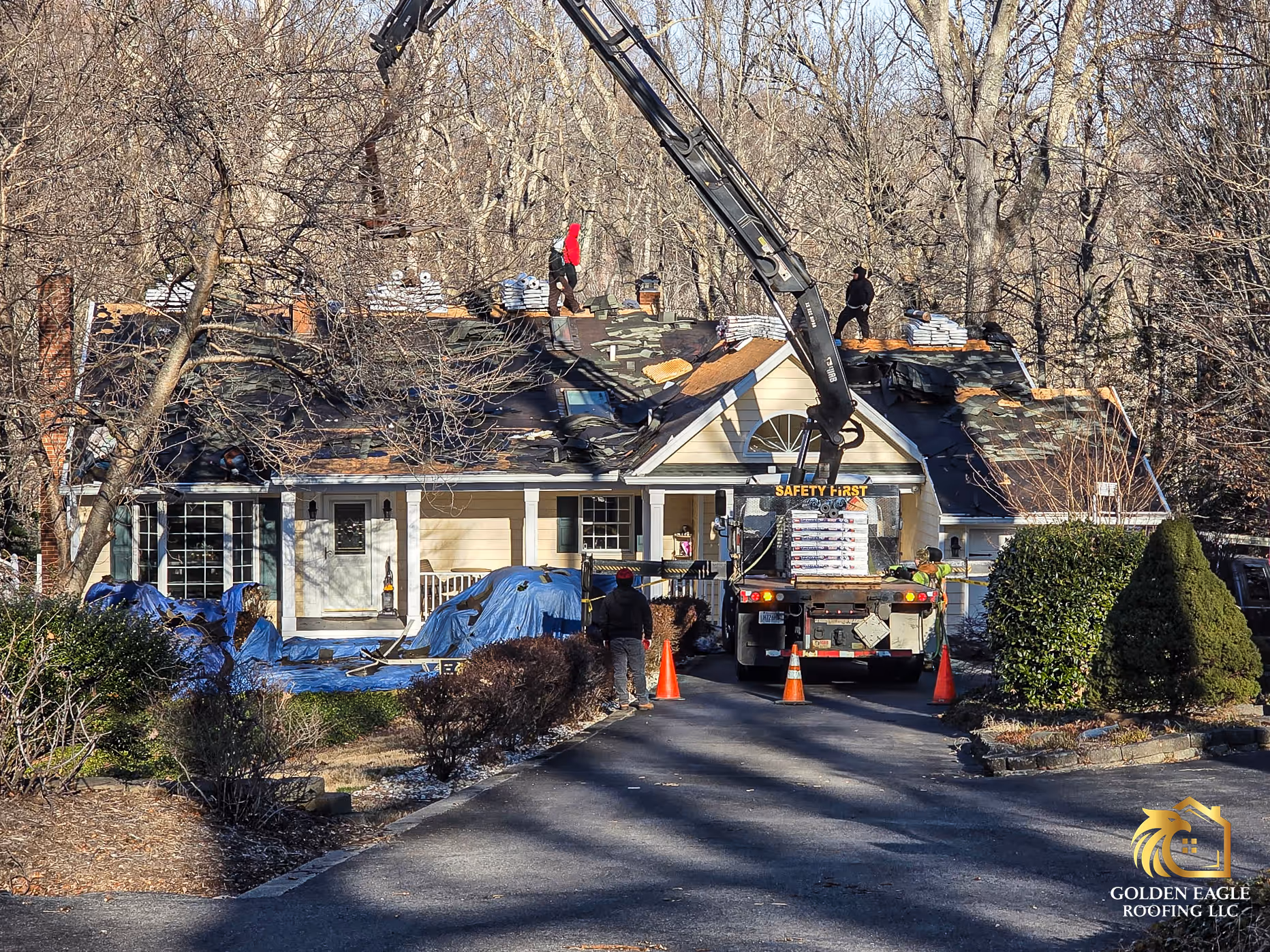 A photo of a crane loading a townhome with Atlas Pinnacle Pristine roof shingles for a insurance-paid roof replacement in North Beach, Maryland by Golden Eagle Roofing, LLC