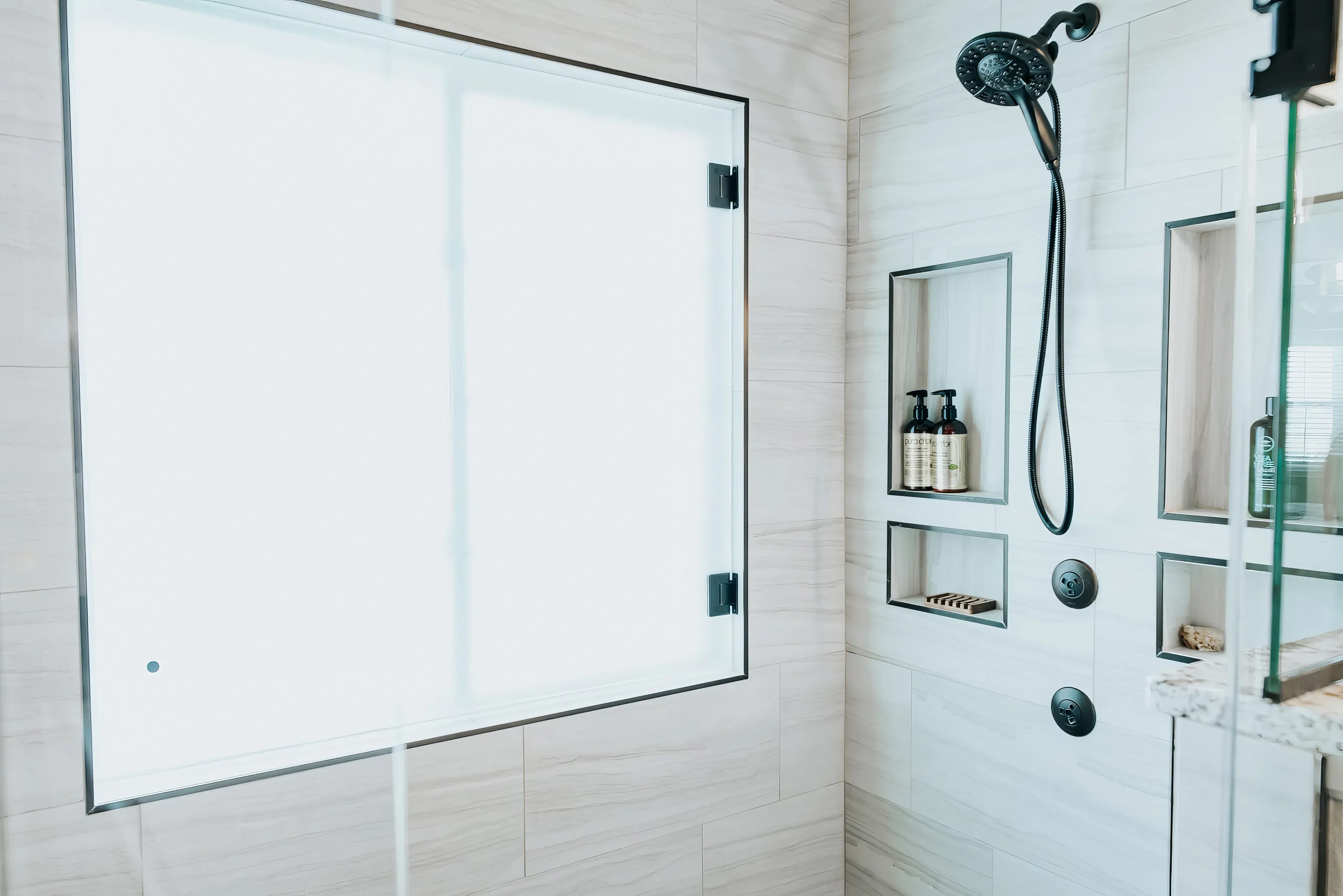 A photograph of a new remodeled bathroom with a walk-in shower & small sauna