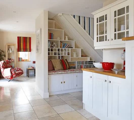 A small bench / bookshelf installed underneath stairs