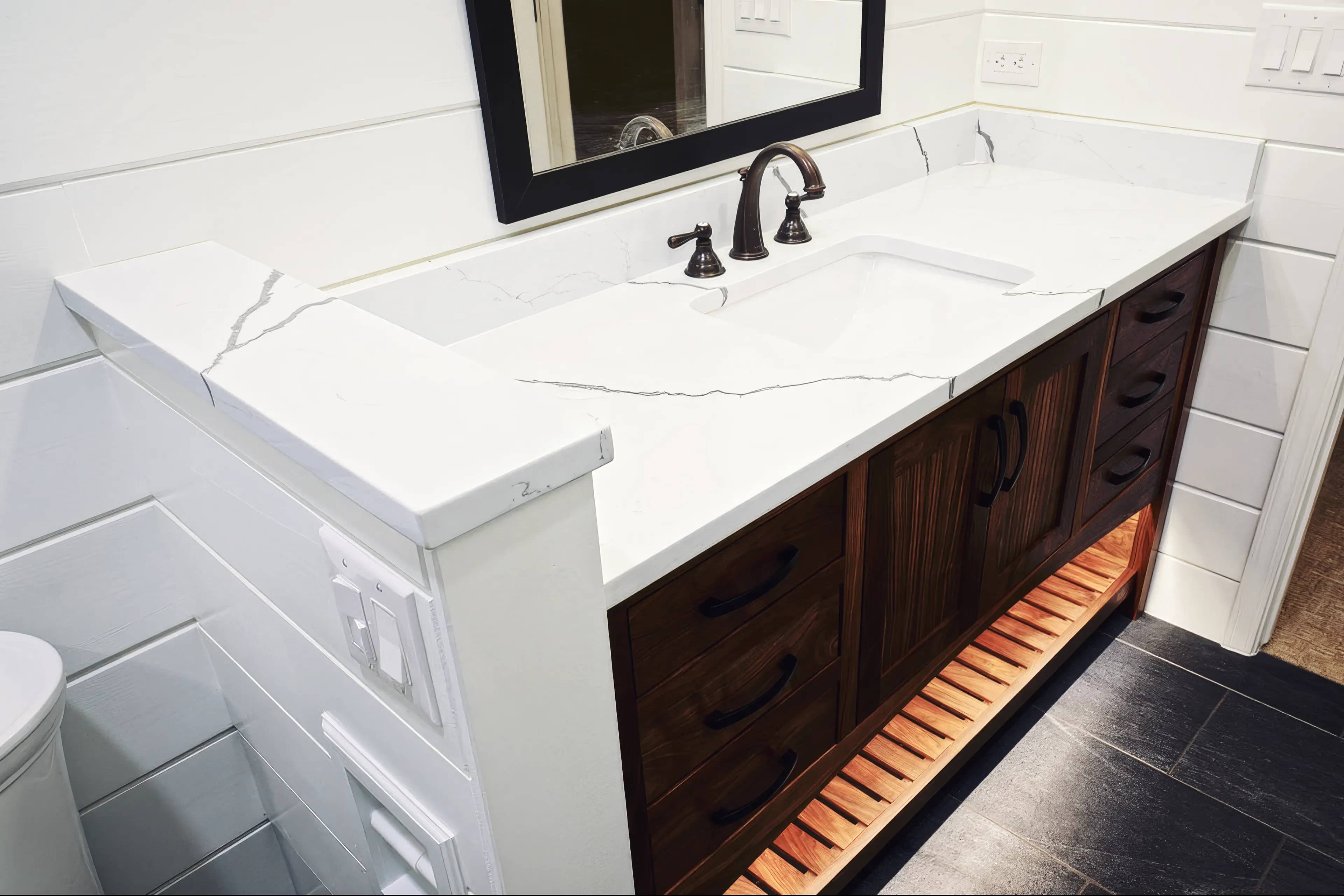 A photograph of a newly installed bathroom counter made of Marble and custom lighting underneath the cabinet in Colorado Springs