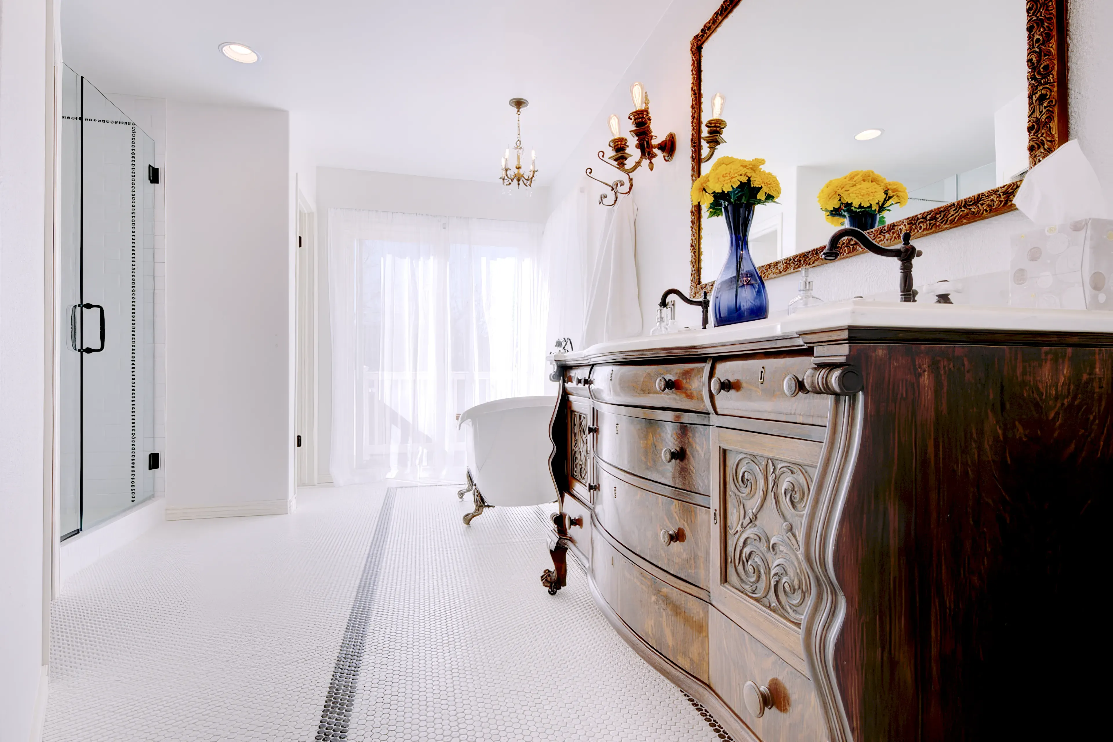 A photograph of a new claw foot tub in a Colorado Springs Bathroom Remodel with custom cabinets and white tile with a black accent strip