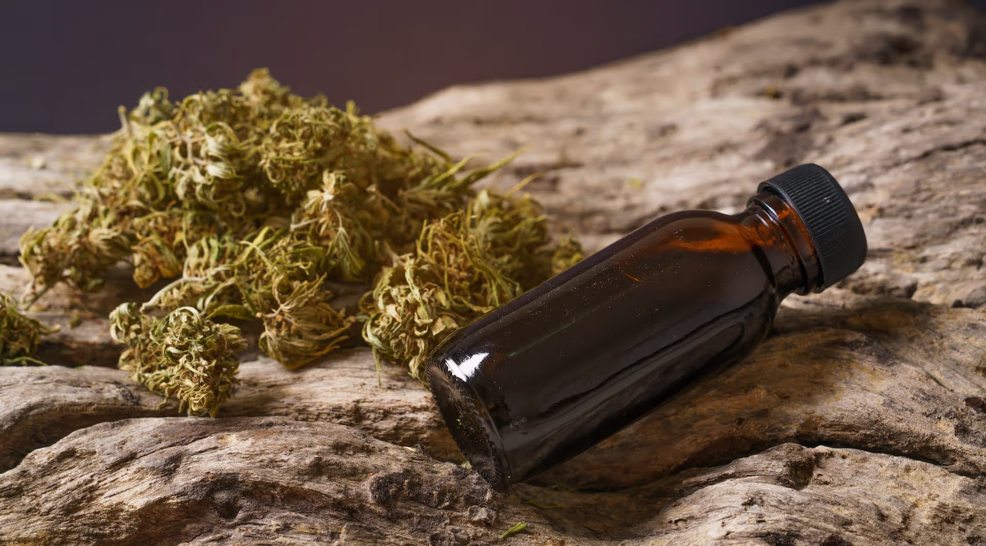 indica cannabis in swampscott with bottle on piece of wood and indica dried leaves
