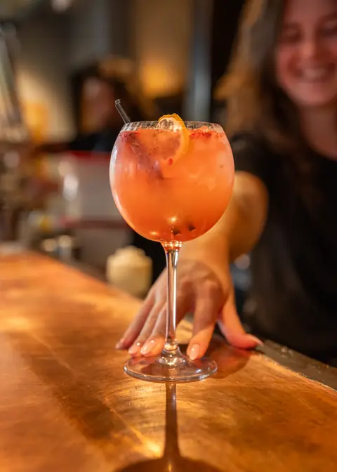 A cocktail being served across the bar