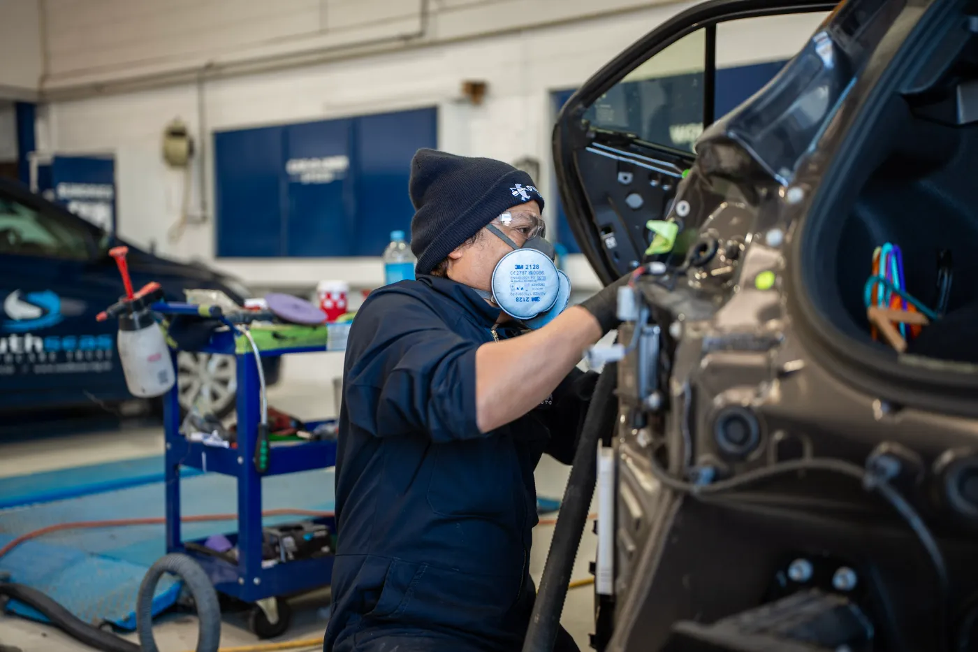 Panel technician repairing a car door in the workshop