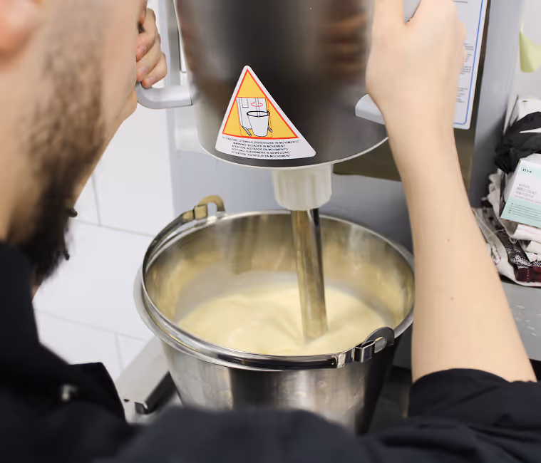 Teilnehmer im Speiseeis Seminar der Eisfachschule Berlin beim Anrühren von Eiscreme-Masse mit professioneller Eismaschine