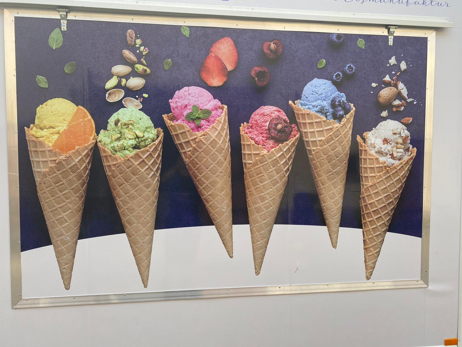 Bunte Eiswaffeln in verschiedenen Sorten wie Orange, Pistazie, Erdbeere, Kirsche, Blaubeere und Nuss