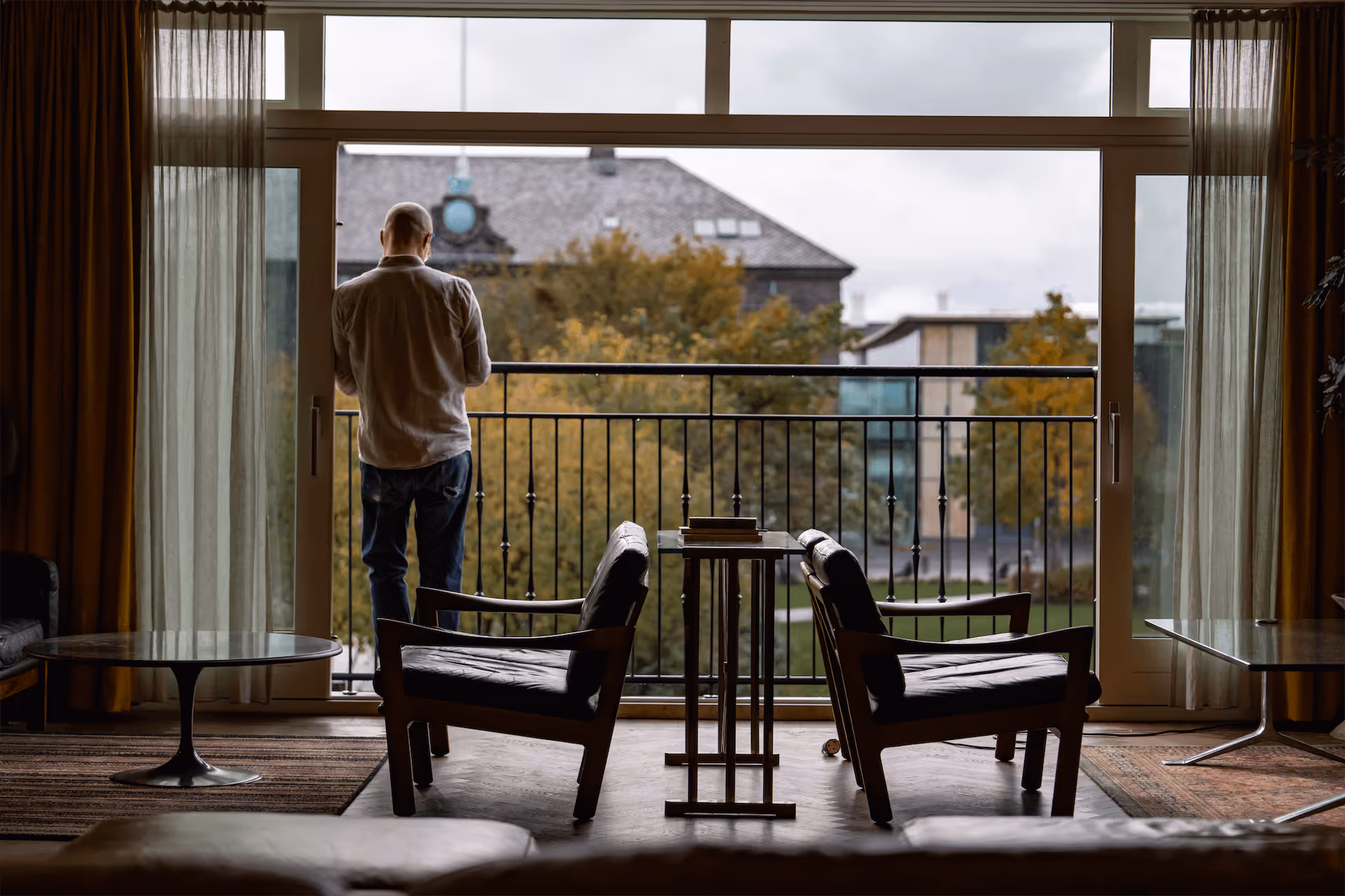Atmospheric lounge view at Fantasia with silhouette gazing at Reykjavik architecture through floor-to-ceiling windows