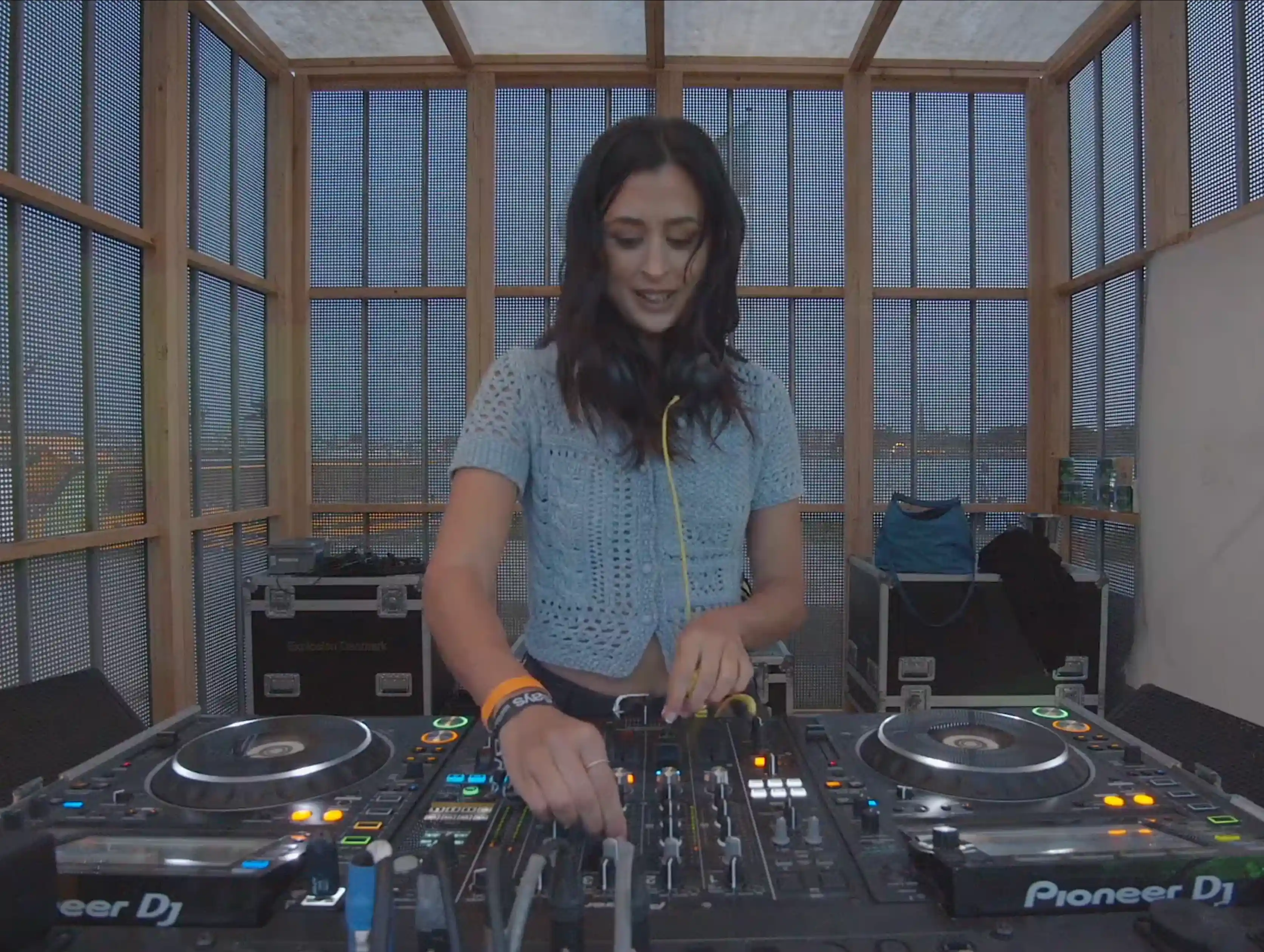 Atusa performing a DJ set at Drift Radio during O Days Festival on August 1, 2024 — focused on the mixing console, wearing headphones, with colorful stage lights and the crowd subtly visible in the background.