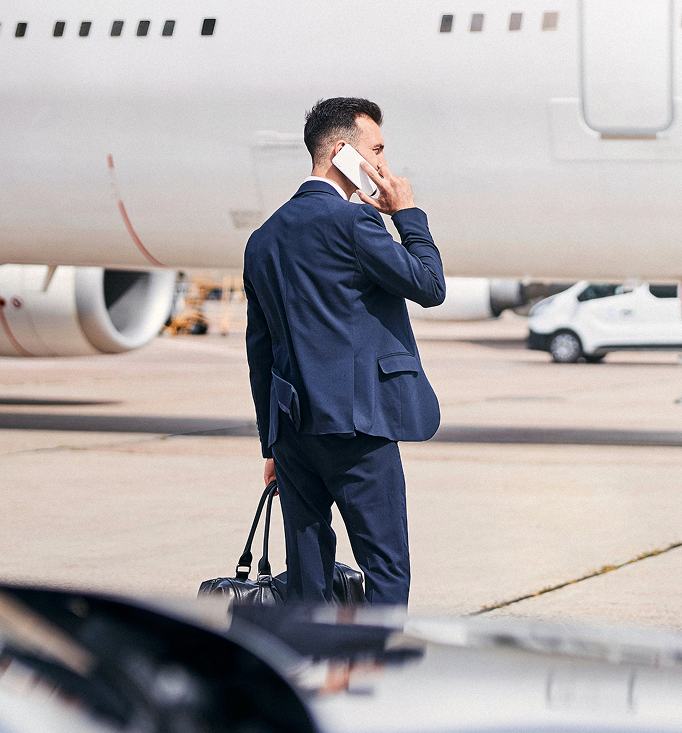 Business traveller standing beside an aircraft