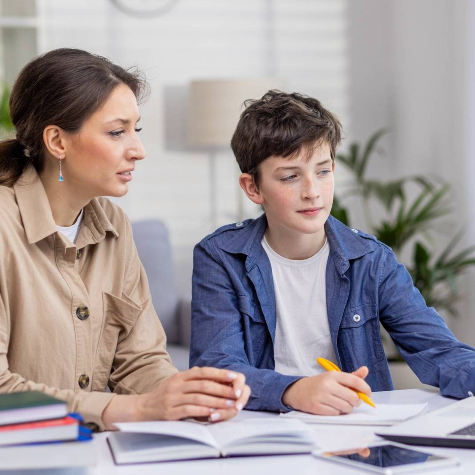 Nachhilfelehrerin unterstützt Schüler beim Lernen zu Hause am Laptop