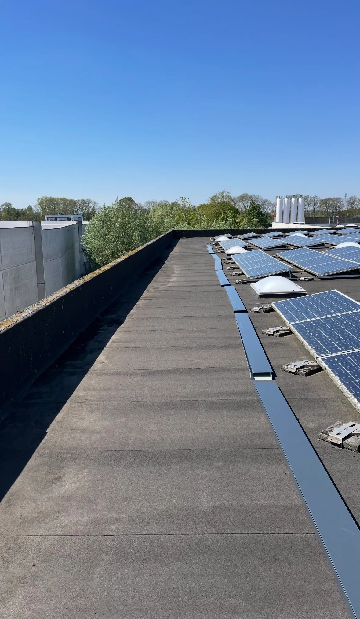Toit plat avec panneaux solaires sous un ciel bleu clair par une journée ensoleillée. reparation fuite