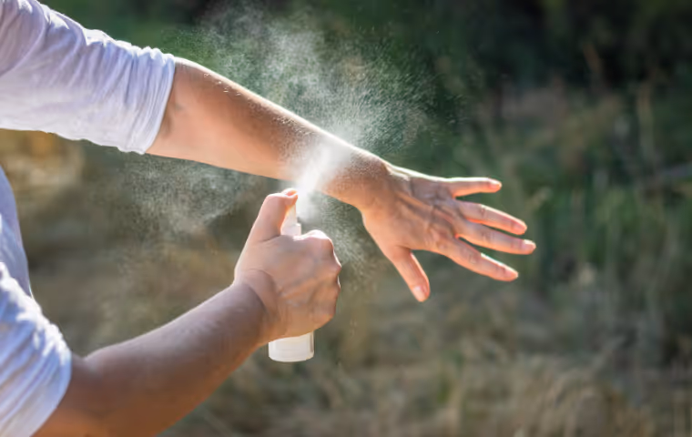 person spraying bug spray