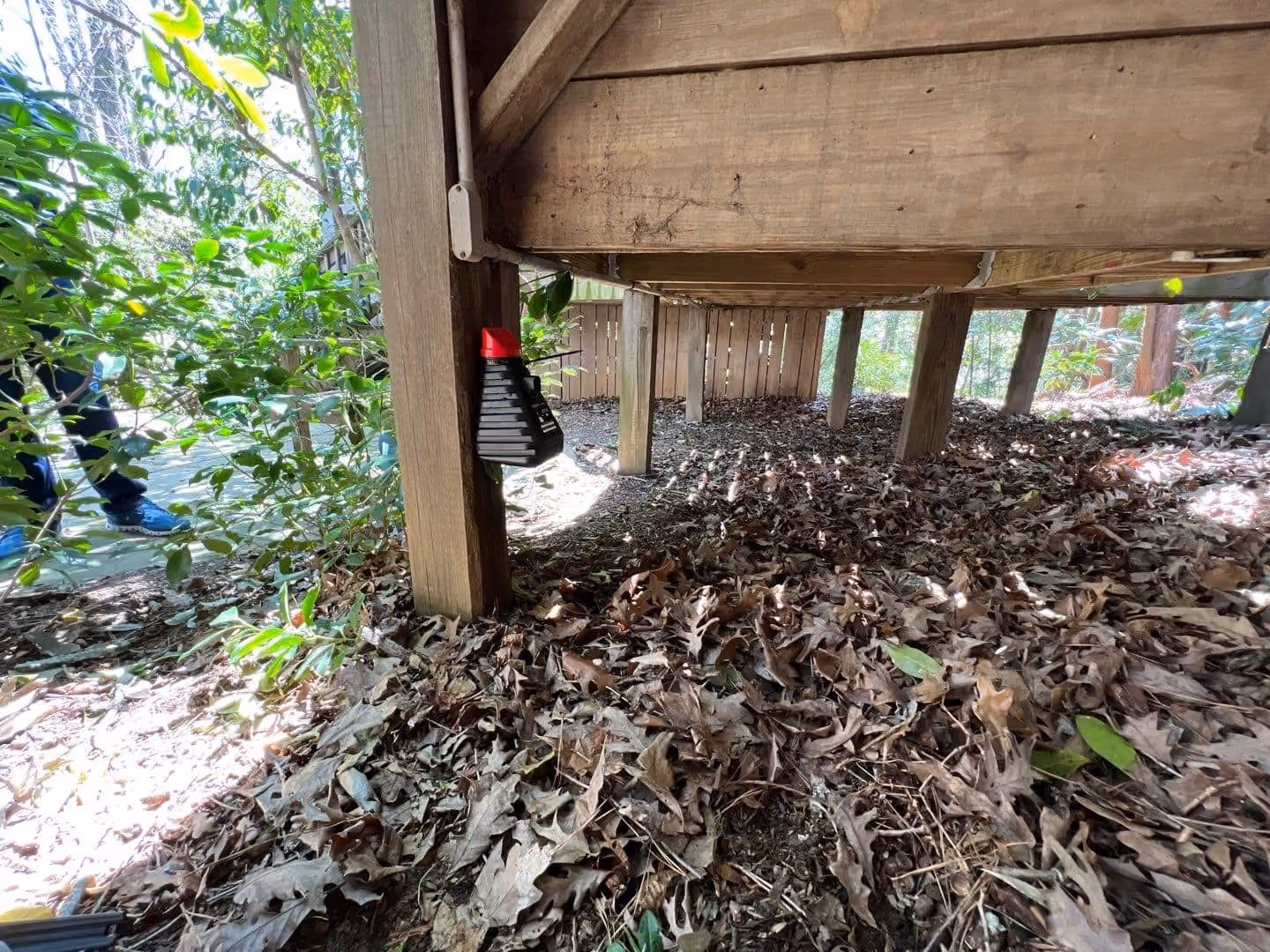 Mosquito trap mounted under a backyard deck