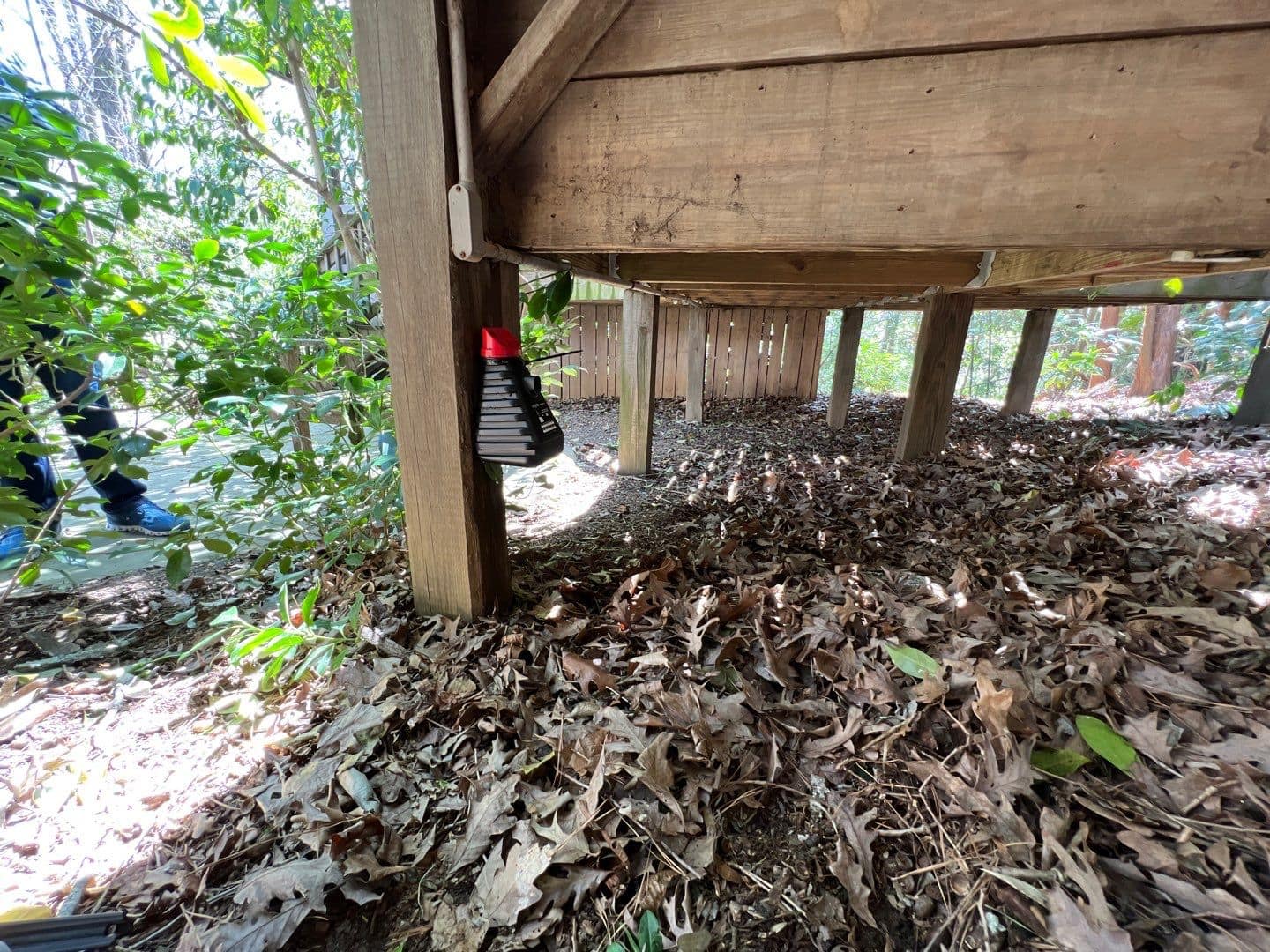 Mosquito trap mounted under a backyard deck