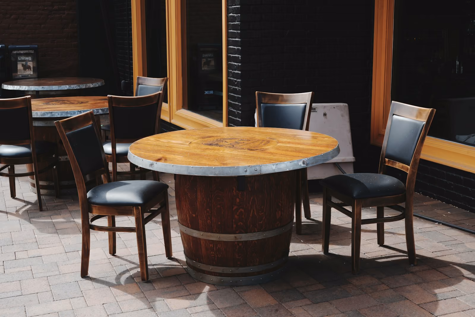 Outdoor restaurant dining tables and chairs on a brick patio