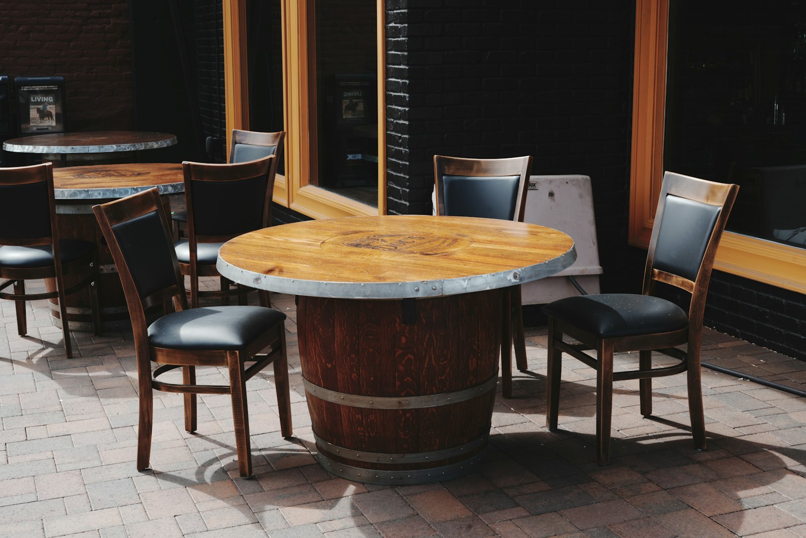 Outdoor restaurant dining tables and chairs on a brick patio