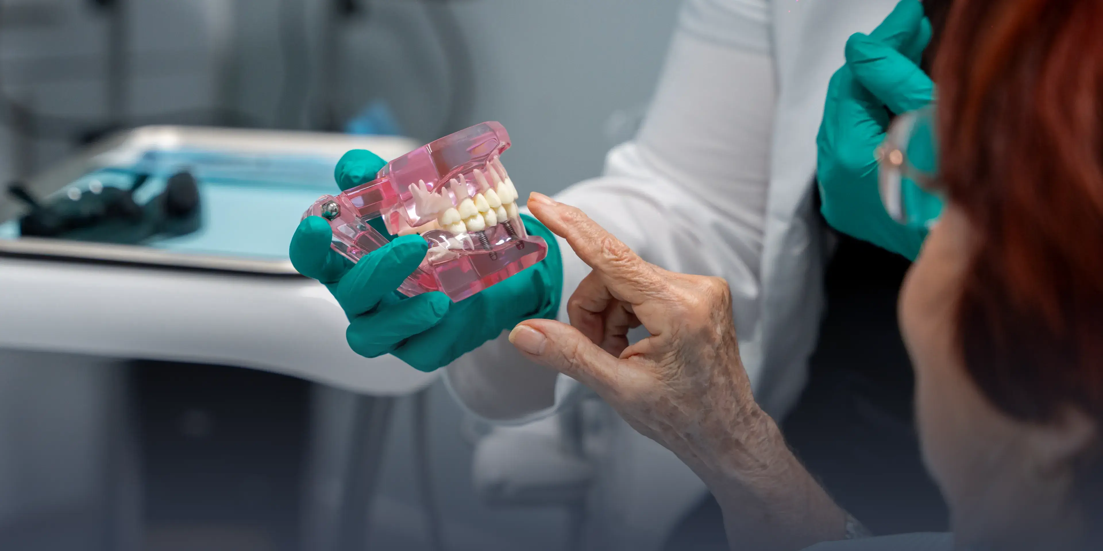 A person holding a toothbrush and a dental model, smiling in a dental office.
