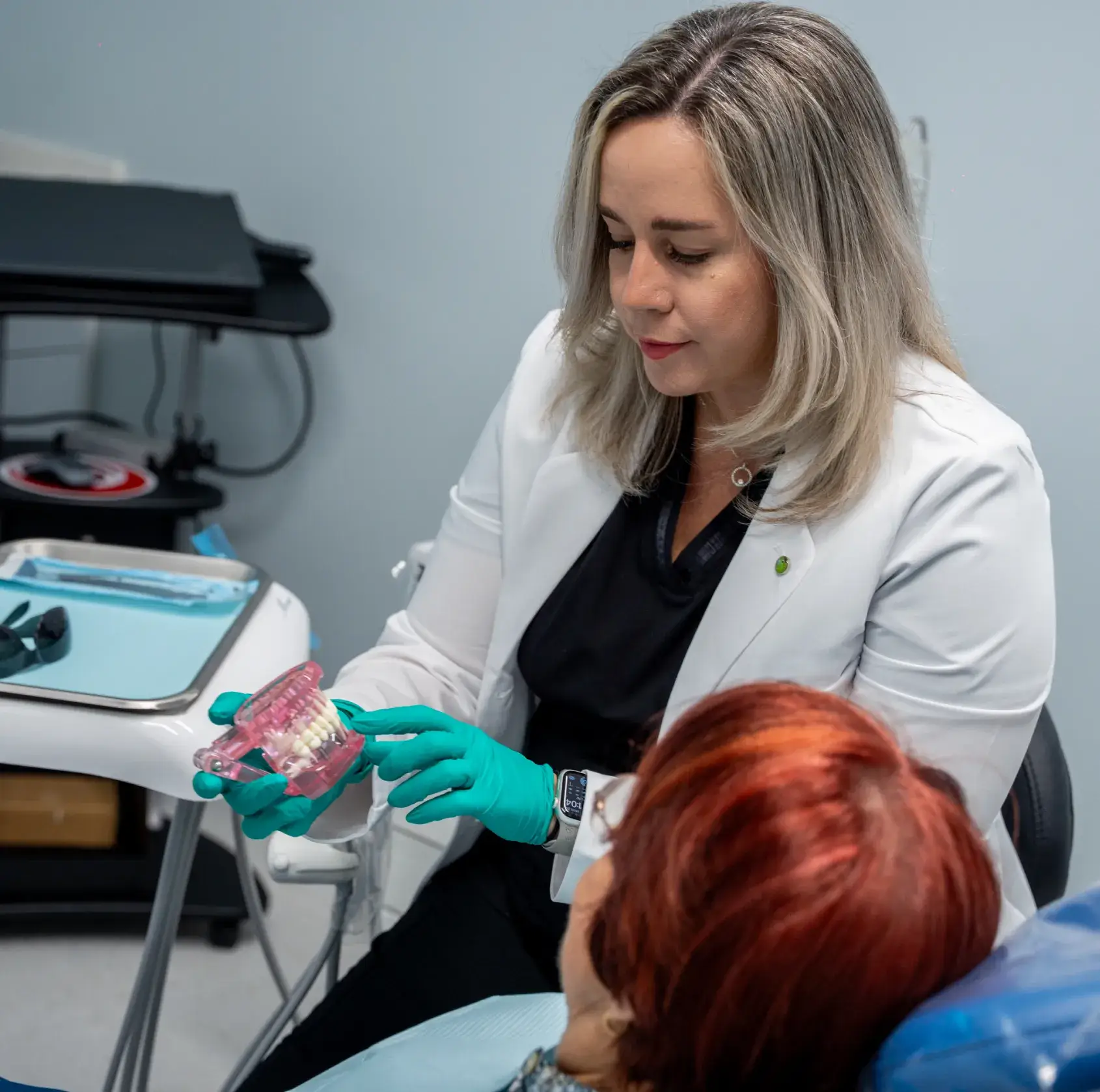 A dentist shows a patient digital dental scans on a screen in a dental office.