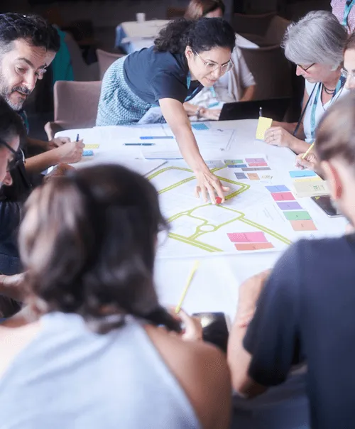 CIU participants engaged in design thinking workshop with visual mapping and colorful sticky notes on collaborative workspace