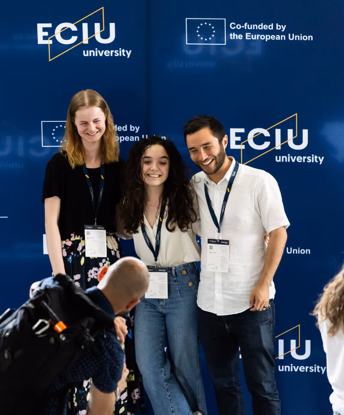 Three ECIU University representatives posing at European Union co-funded event photo wall