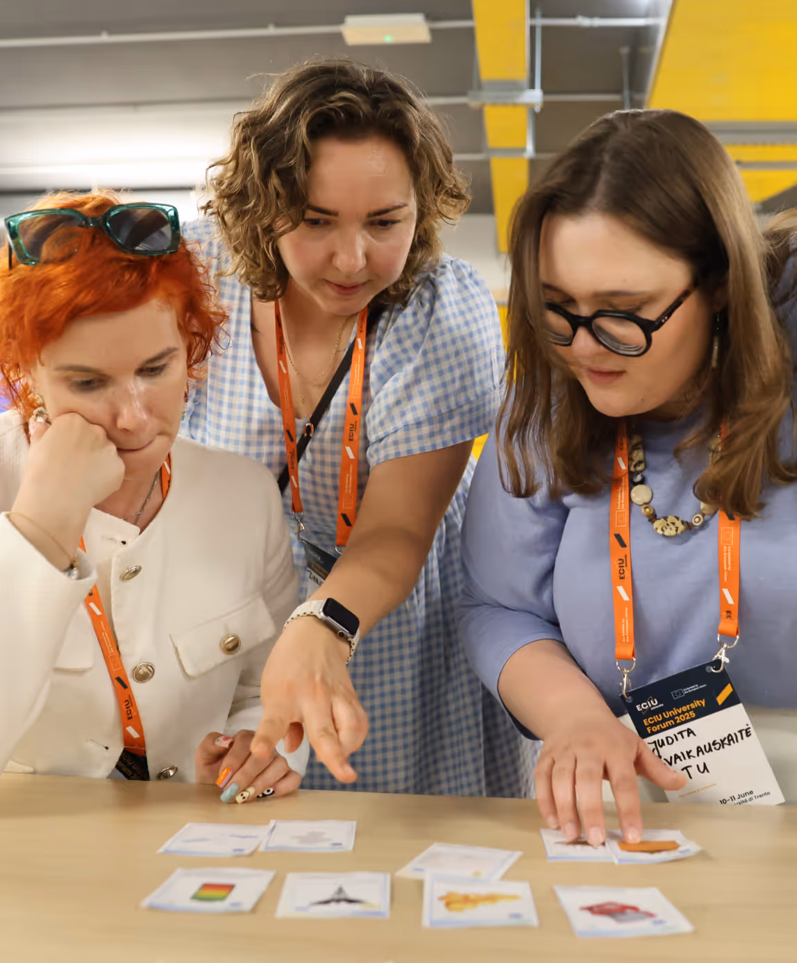 Three ECIU researchers collaborating over workshop materials at university forum event