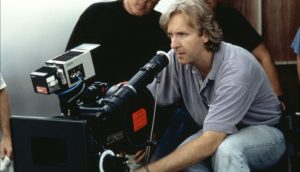 Réalisateur de film concentré derrière la caméra pendant une prise, représentant la direction et la supervision du tournage.