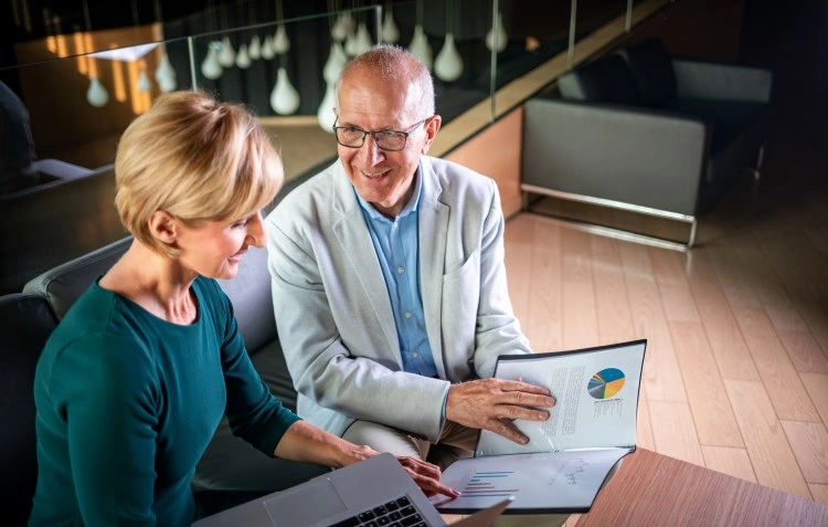 Business meeting in a modern interior — review of documents with graphs, smiles and conversation.