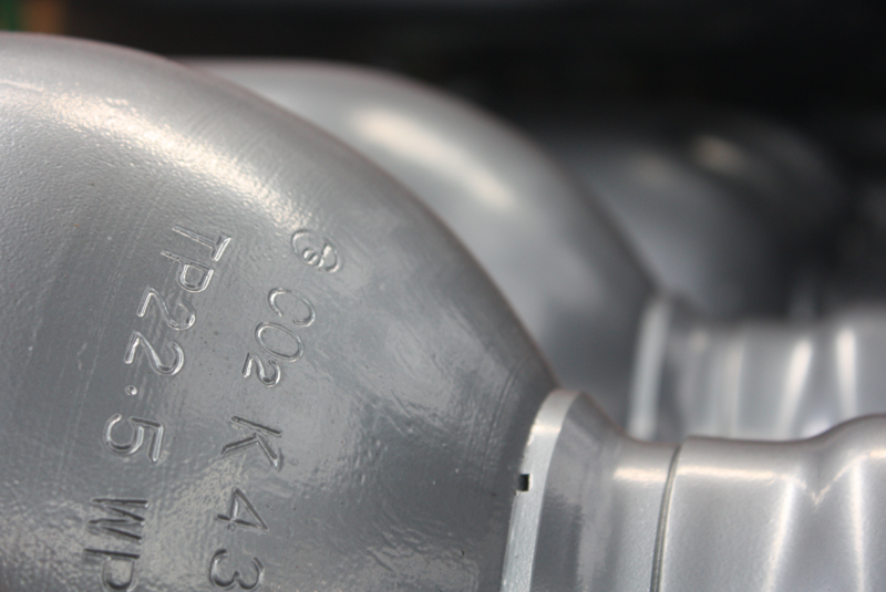 Close-up of gray metallic cylinders with engraved alphanumeric markings.