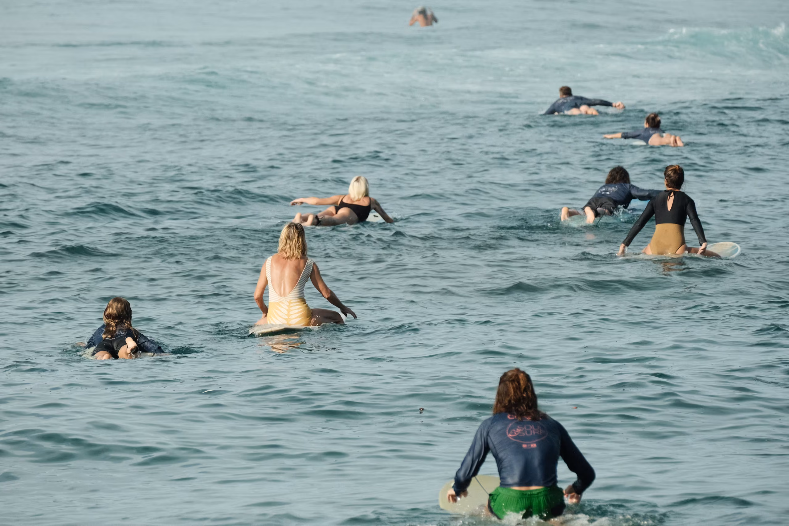 Surfers paddling in the lineup at Kabalana surf break, Ahangama, Sri Lanka