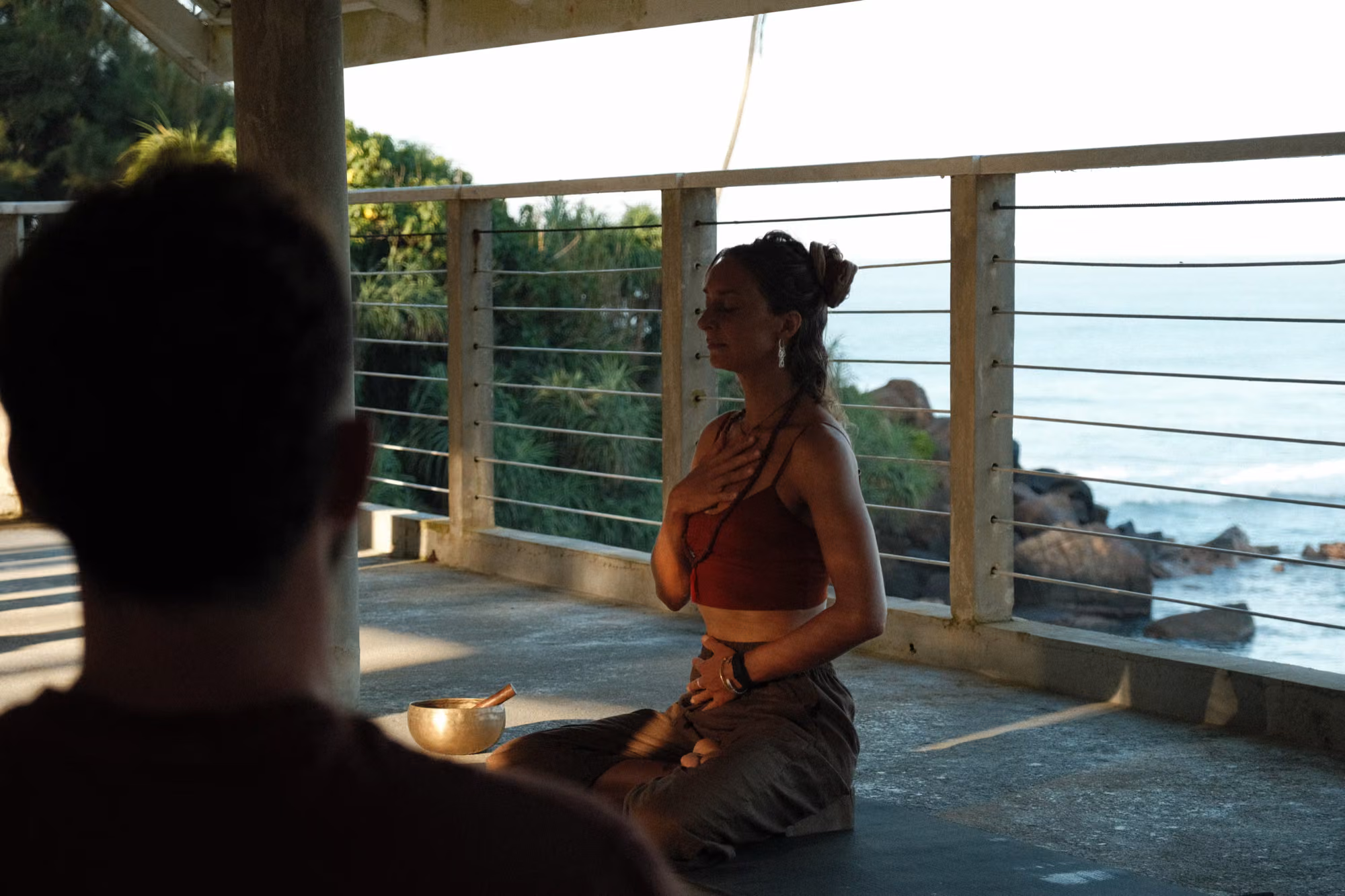 Yoga meditation session with singing bowl on an open deck overlooking the ocean near Licuala Lanka, Ahangama, Sri Lanka