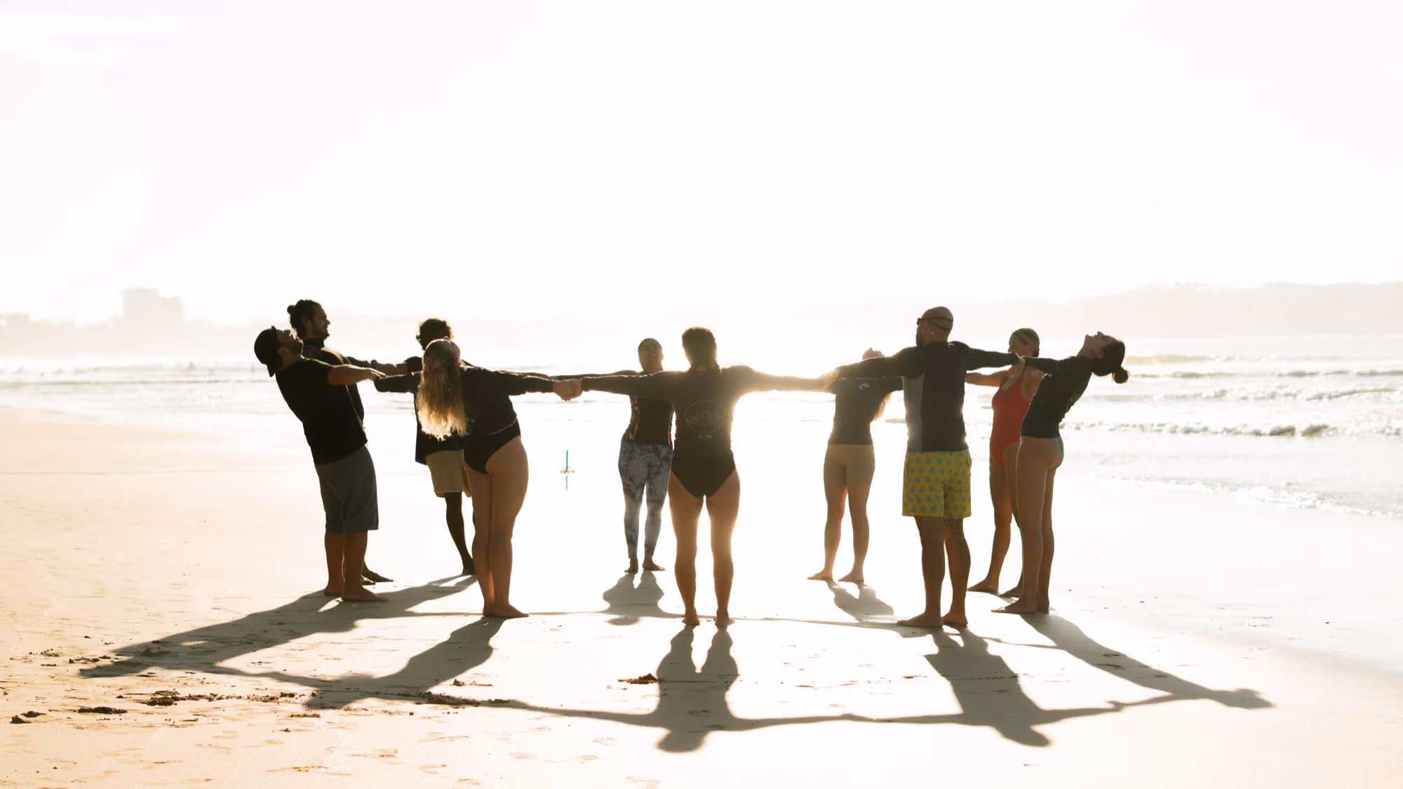 Surf and yoga group stretching together at sunrise on Kabalana beach near Licuala Lanka, Ahangama, Sri Lanka