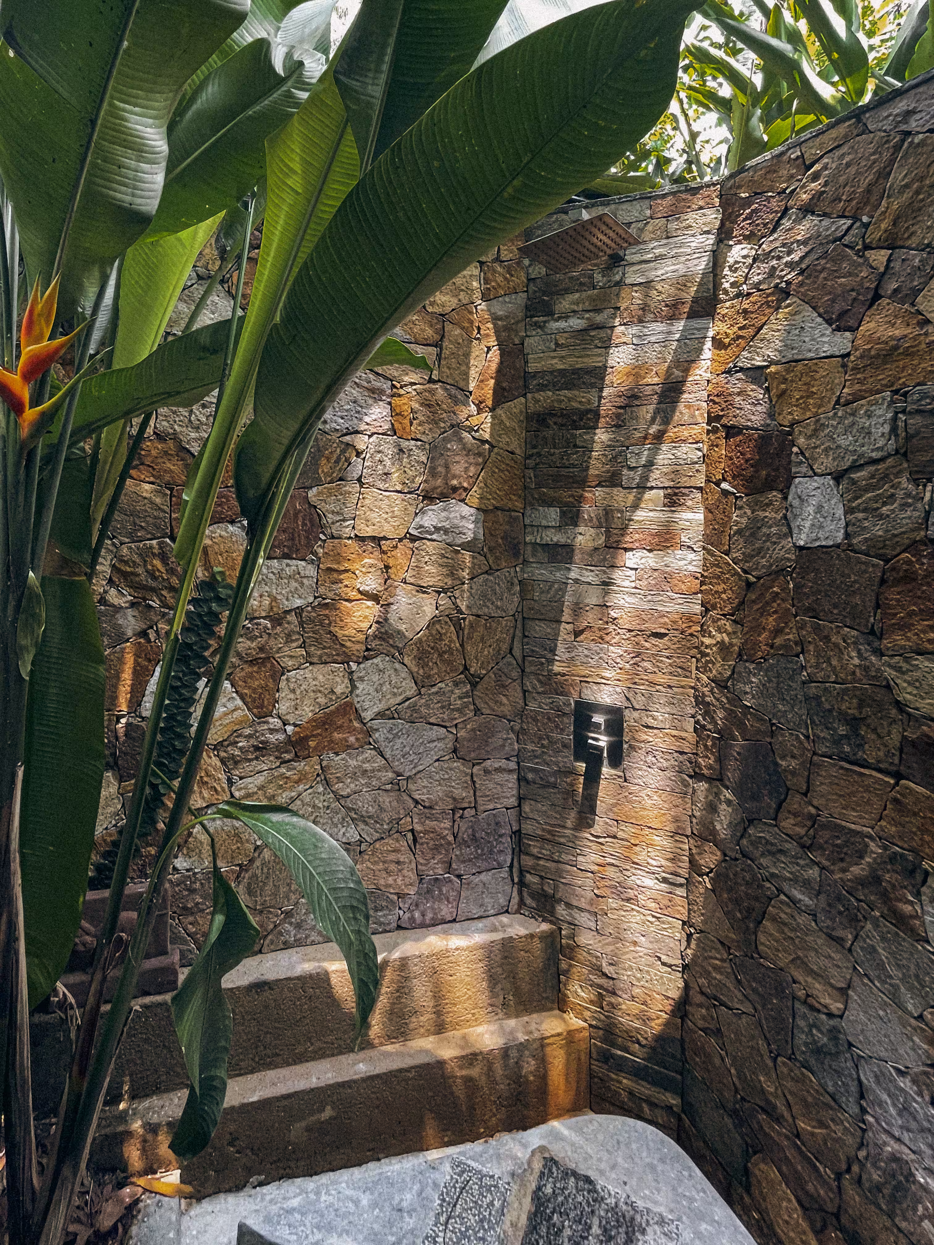 Cozy living space with glass walls overlooking tropical greenery