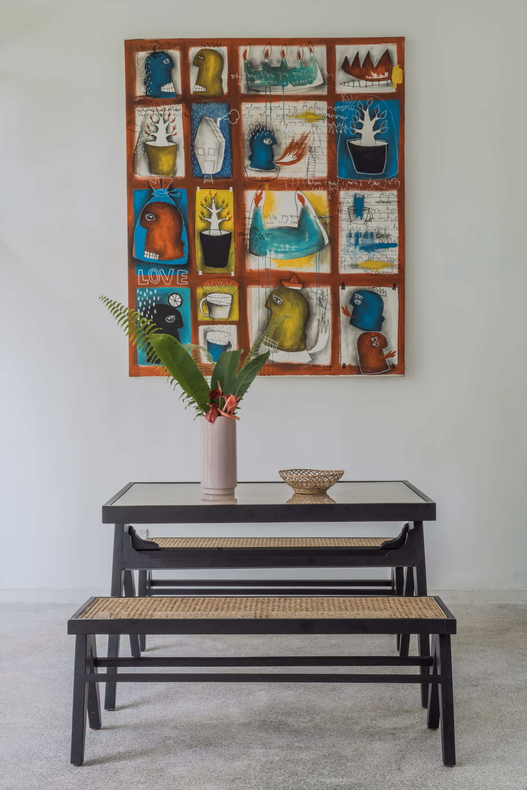 Dining table with benches and local artwork inside the Garden House at Licuala Lanka on Sri Lanka's South Coast
