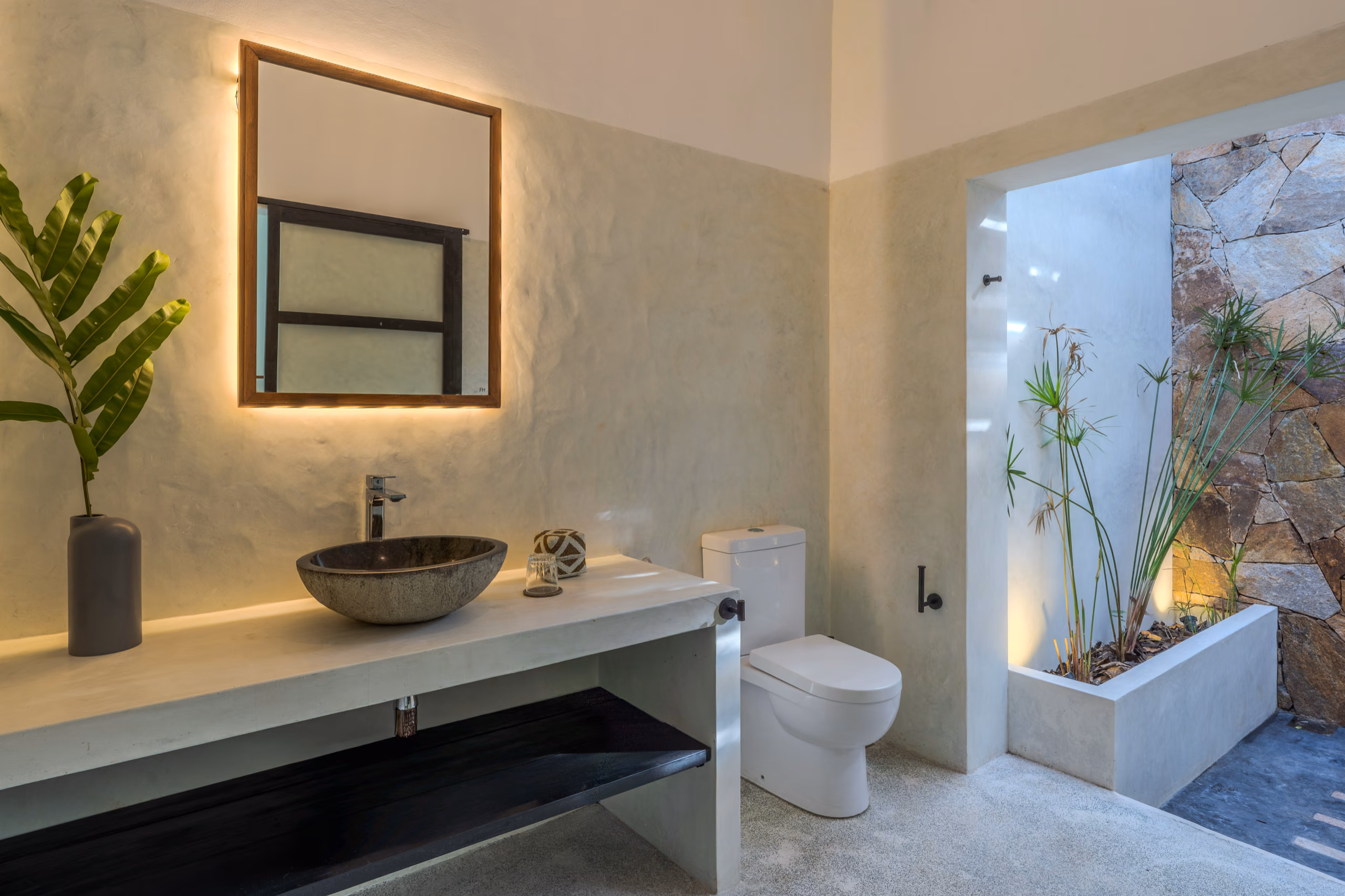 Open-air bathroom with stone wall and planters in the Garden House at Licuala Lanka, Ahangama, Sri Lanka