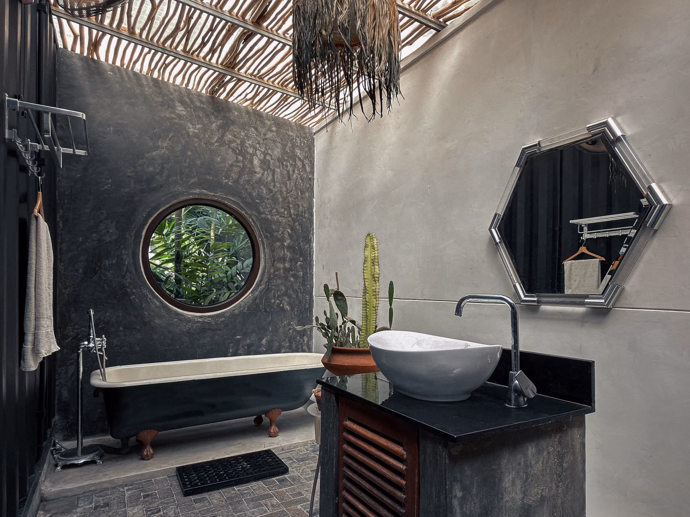 Bathroom with freestanding tub and round window in the Jungle Home, Licuala Lanka near Kabalana Beach, Sri Lanka