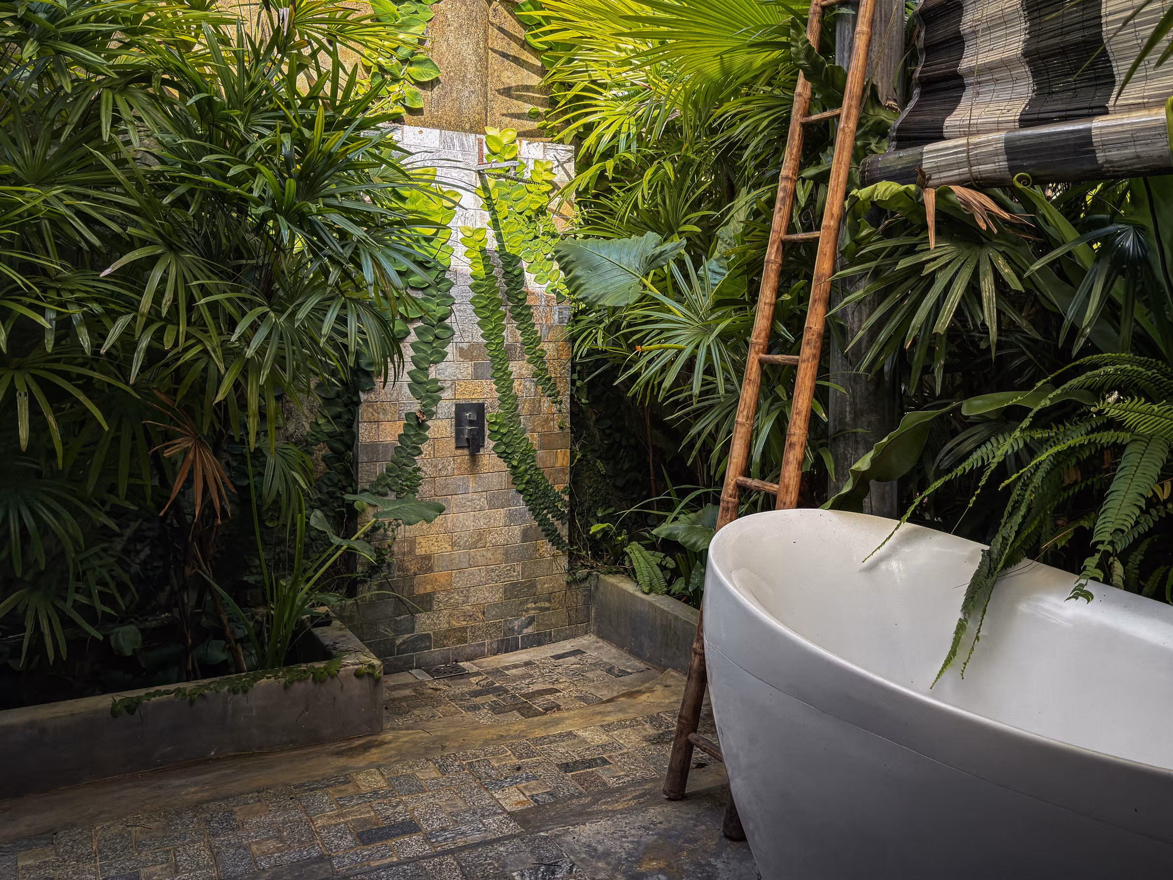 Outdoor bathtub by the stone wall at the Jungle Home, Licuala Lanka near Kabalana Beach, Sri Lanka