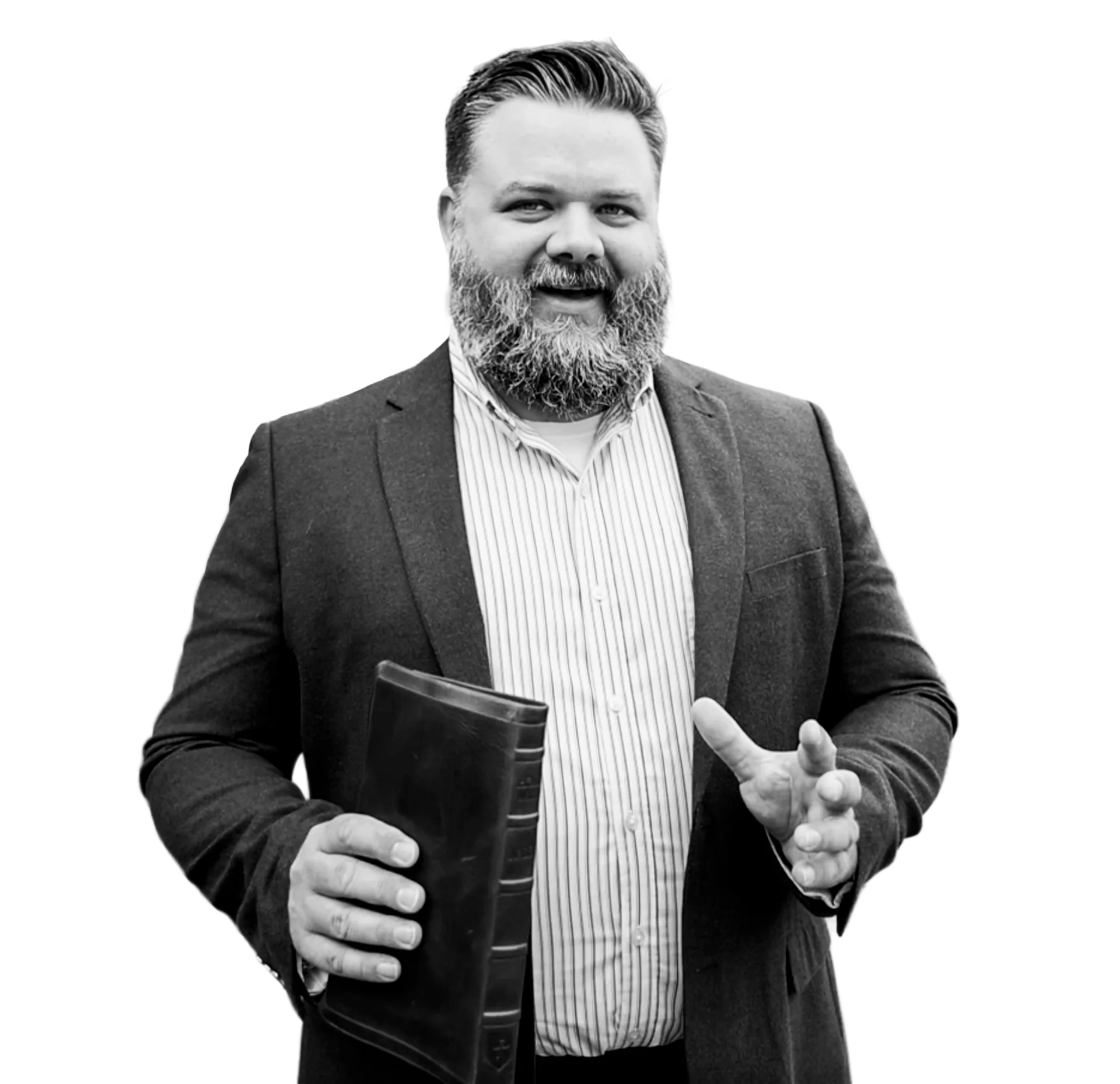 Smiling bearded man in a suit holding a closed book and gesturing with his other hand.