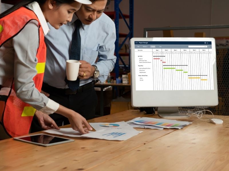 Equipo de construcción revisando reportes y cronogramas digitales para analizar avances, coordinar actividades y dar seguimiento a la ejecución del proyecto