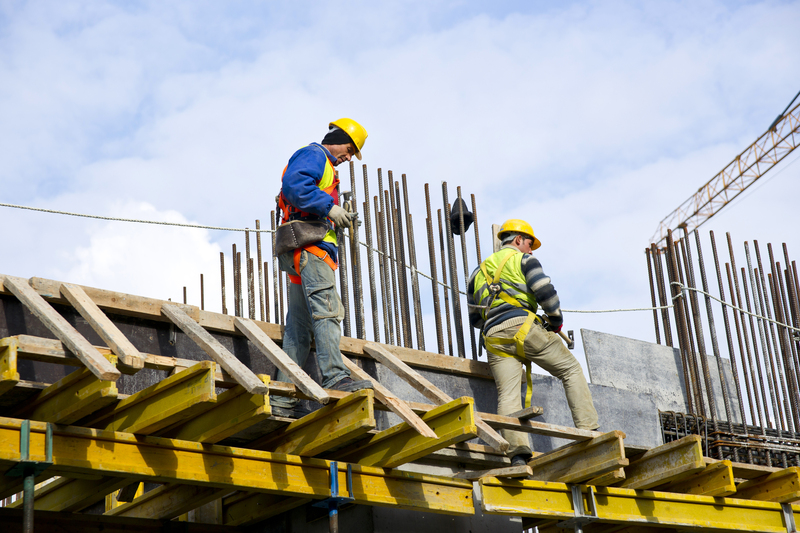 Trabajadores de construcción realizando labores sobre una estructura con acero de refuerzo, reflejando la ejecución, supervisión y avance físico de una obra gestionada con Diazar.